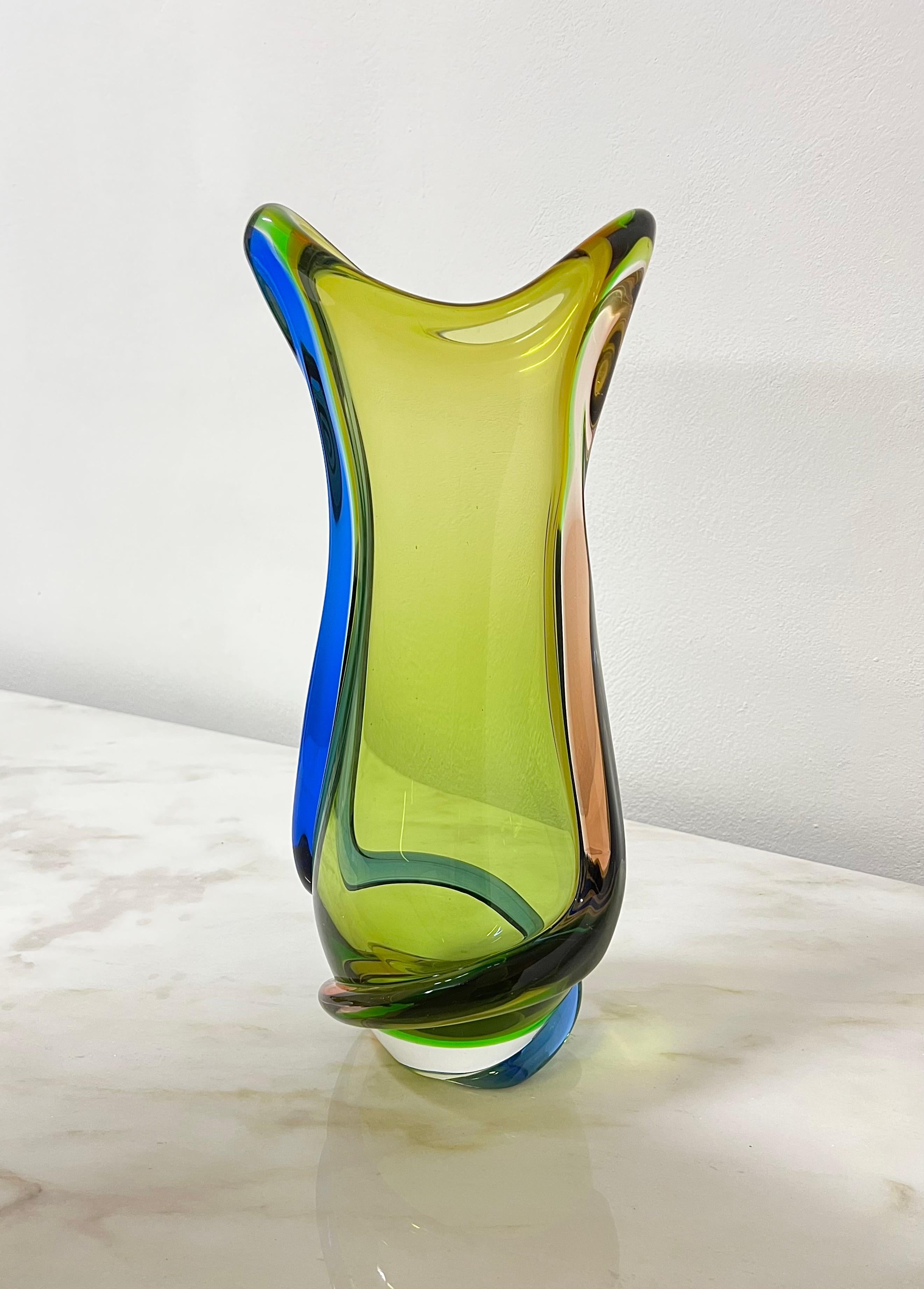 Imposing vase attributed to Flavio Poli and produced in Italy in the 70s. The vase was made of Murano glass in forest green with two cords at the extremity, one in electric blue and one in caramel, which together give the object a particular