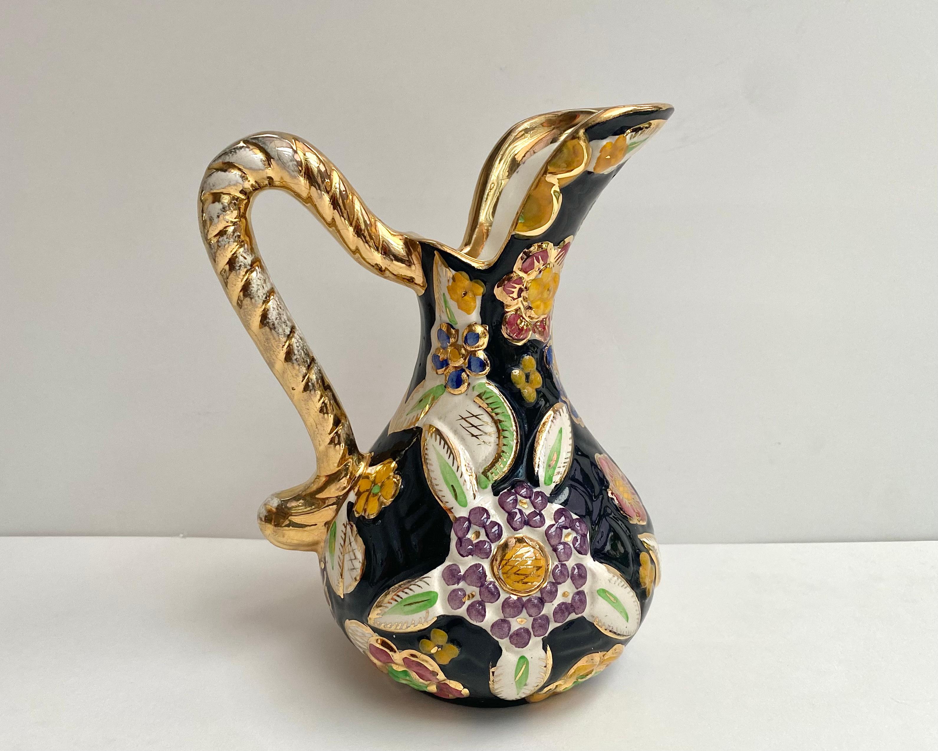 From the 1950s, attributed to Hubert Bequet Quaregnon ceramic pitcher/vase with a beautifull black background decorated with a bright colorful raised enamel pattern of a colorful flowers.

  All hand crafted and hand painted.  

All accents in 24k