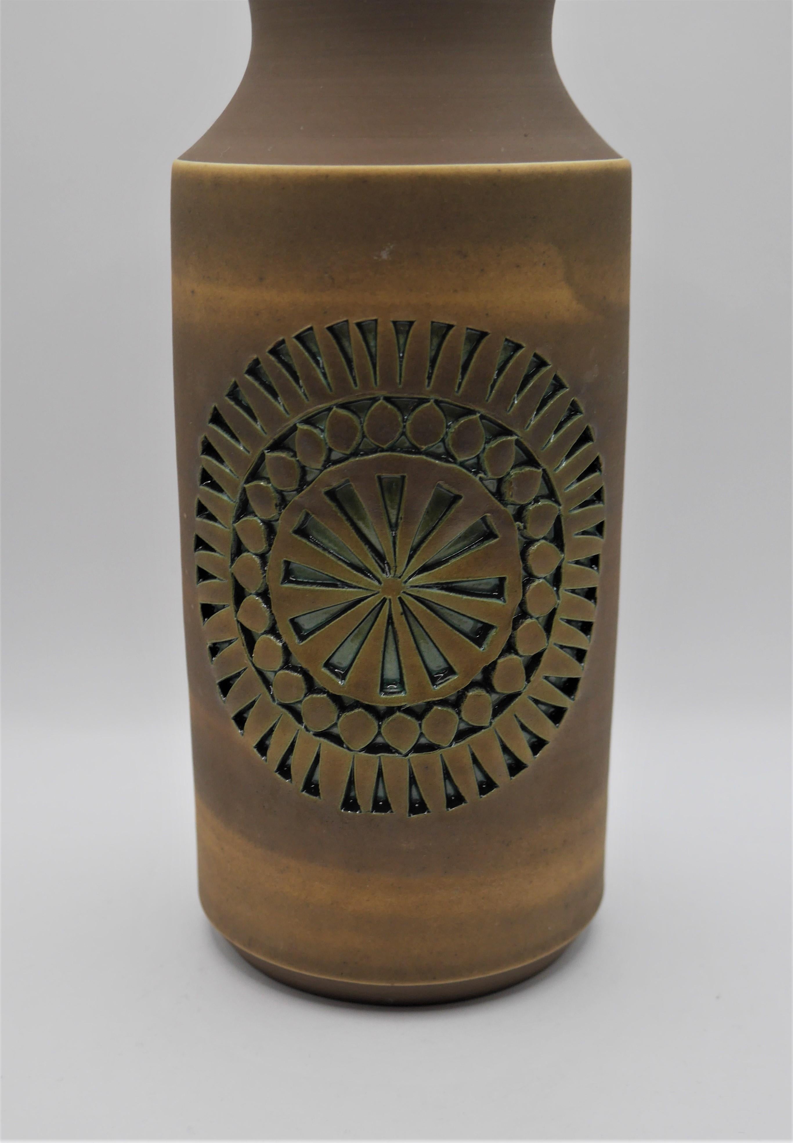 A beautiful, piece by Tomas Anagrius for Alingsås ceramics, Sweden. A warm, pale brown and green glaze with a large circular motif on one side. 

Alingsås Keramik was started in 1947 by Halvard Oldberg and Hilding Canemark. In the beginning,
