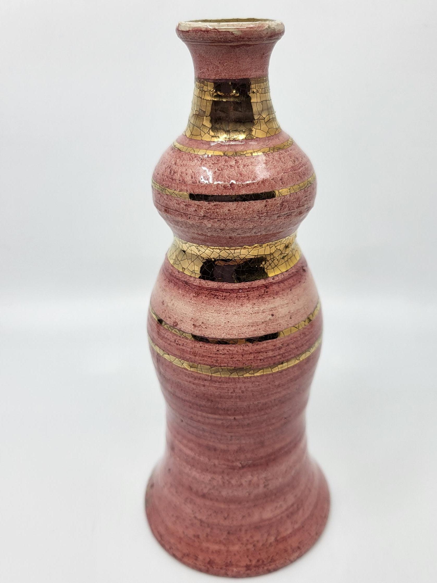 Ce vase soliflore en céramique émaillée rose de Georges Pelletier, agrémenté de délicates finitions dorées à l’or fin, représente un exemple magnifique de l’art de cet artiste belge. Dans un état remarquable, il ne présente ni fêlures ni grenures,