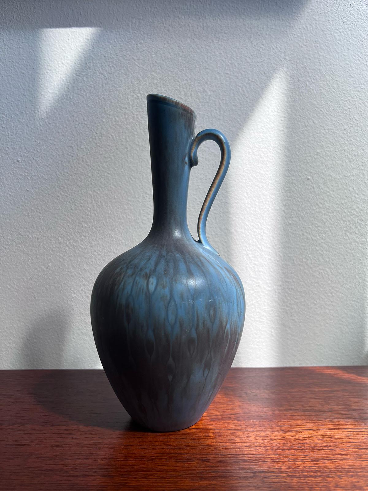 Vase in blue-glazed stoneware designed and signed by Gunnar Nylund and produced by Rörstrands in Sweden, 1950s.

Date of manufacture: 1950s
Origin: Sweden
Material: blue-glazed stoneware
Dimensions: height 22 cm x diameter 6 cm
Condition: in very