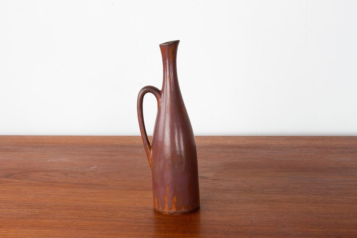 Superbe vase-pichet monofloral en céramique émaillée brun chocolat à bord blanc, modèle Auping, monogrammé et marqué sous la base. Un objet extrêmement raffiné, d'une grande finesse et en excellent état.

Concepteur : Gunnar Nylund.
Fabricant :