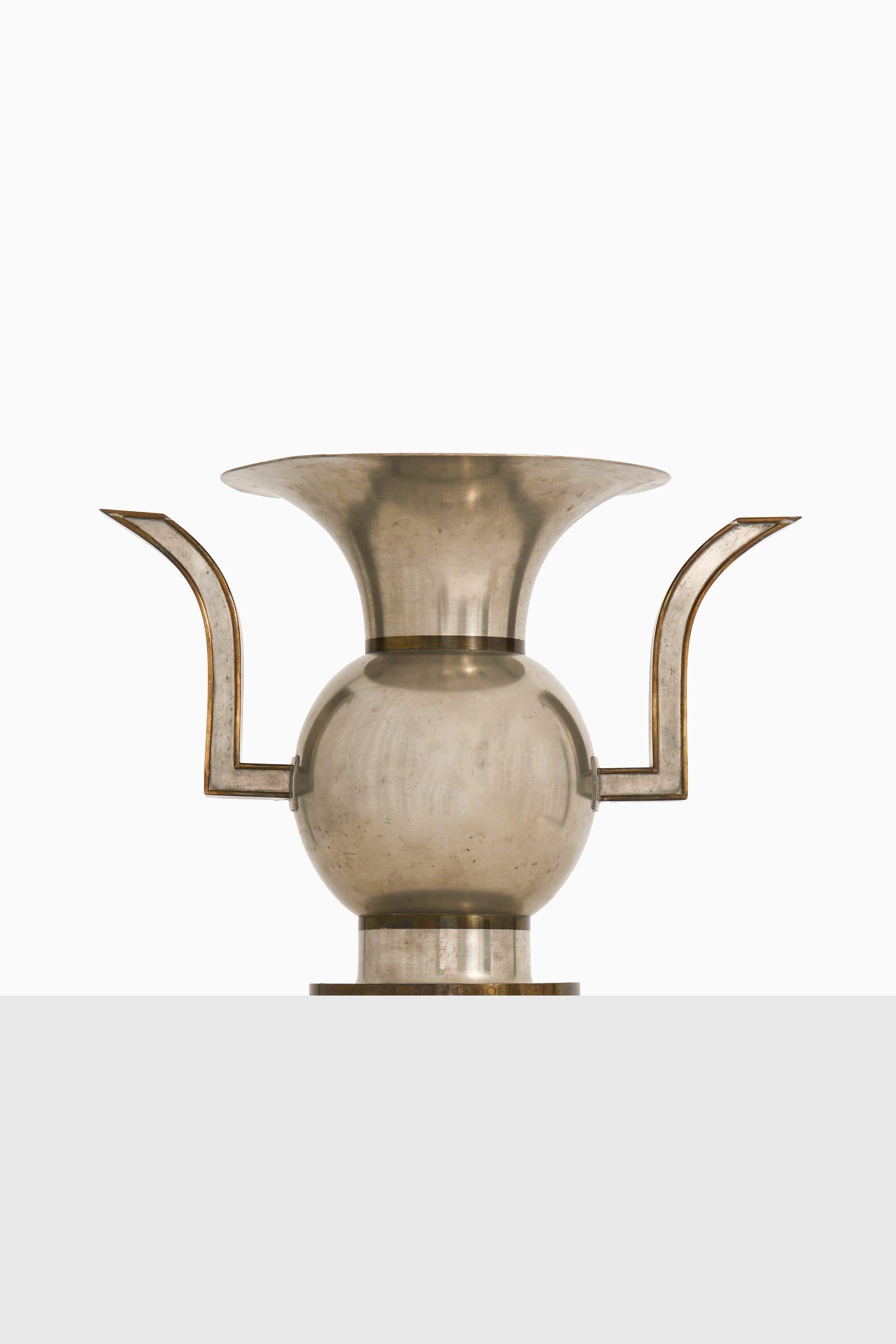 Vase in Pewter and Brass by Nils Fougstedt, 1929

Additional Information:
Material: Pewter and brass
Style: Mid century, Scandinavian
Produced by Svenskt Tenn in Sweden
Dimensions (W x D x H): 34 x 22 x 25 cm
Condition: Good vintage condition, with