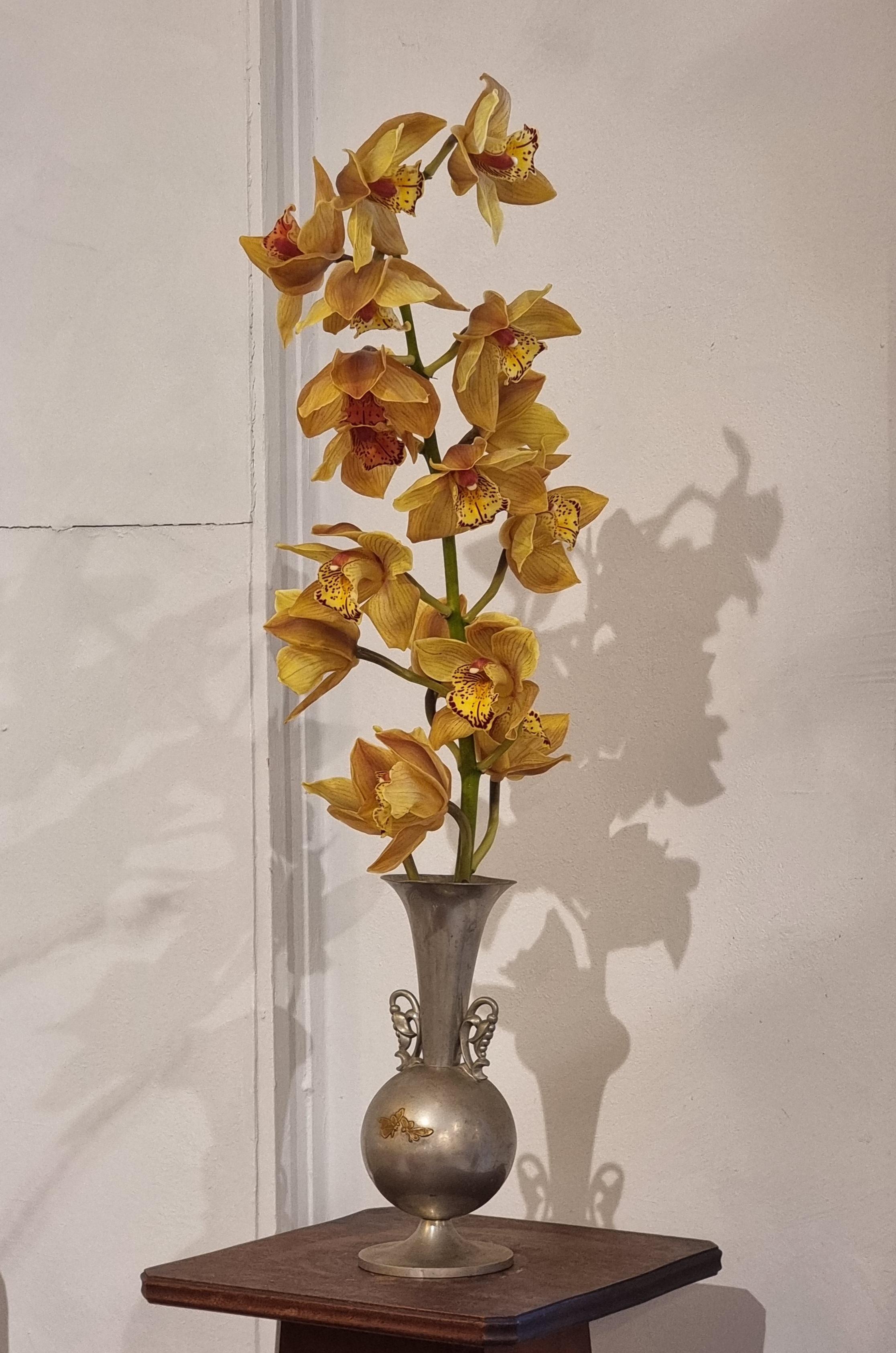 Vase in pewter with brass inlay depicting butterflies, beautiful flowershaped handles. 

Made by KE & Co, Sweden 1934 / Swedish Grace. In good condition, the vase tilts a little. A charming, timeless and rare pieces, both functional and decorative.