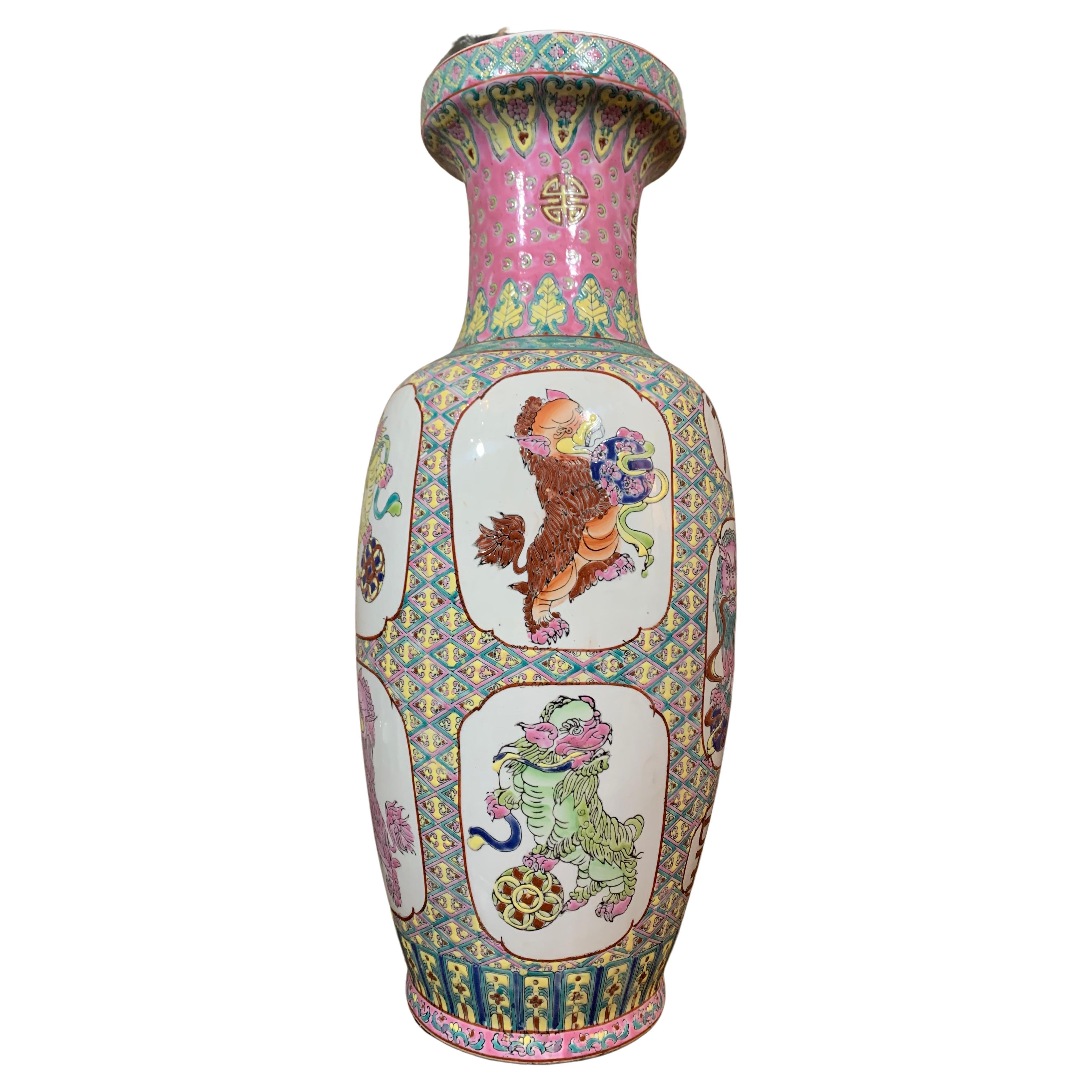 Ce grand vase est en porcelaine de Canton, fabriquée en Chine au début du XXe siècle. Ce vase a des poignées doubles sur les deux côtés, avec des formes animales et dorées. On peut voir des décorations en résine, qui sont des espaces blancs souvent