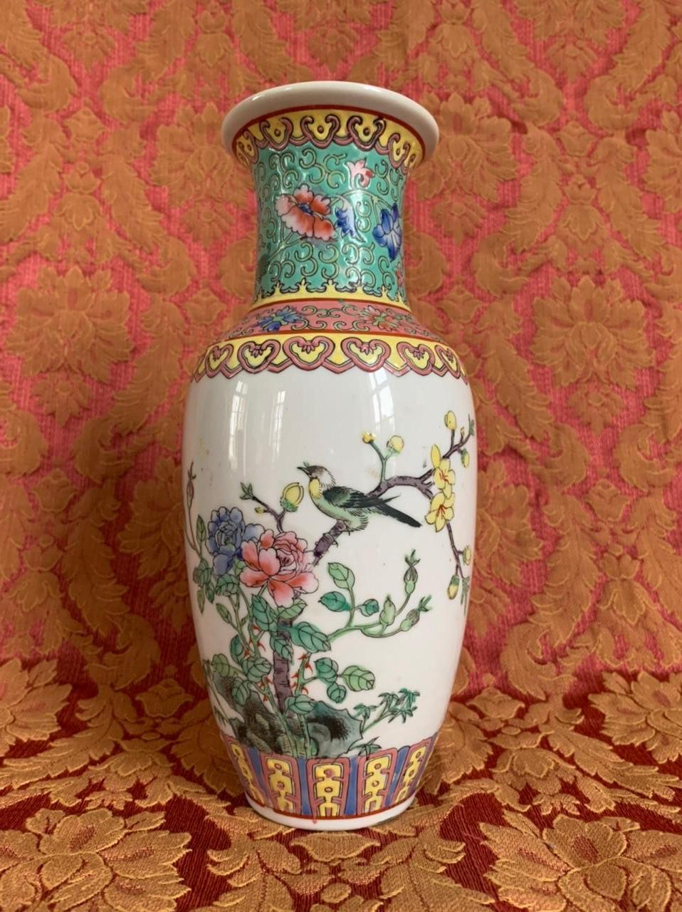 This small vase is made from Canton porcelain and was created in China in the 20th century. 
Composed of ornamental motifs such as plants and interlacing, this vase is pink, blue-green and pale yellow. On the main face of the vase, we find the