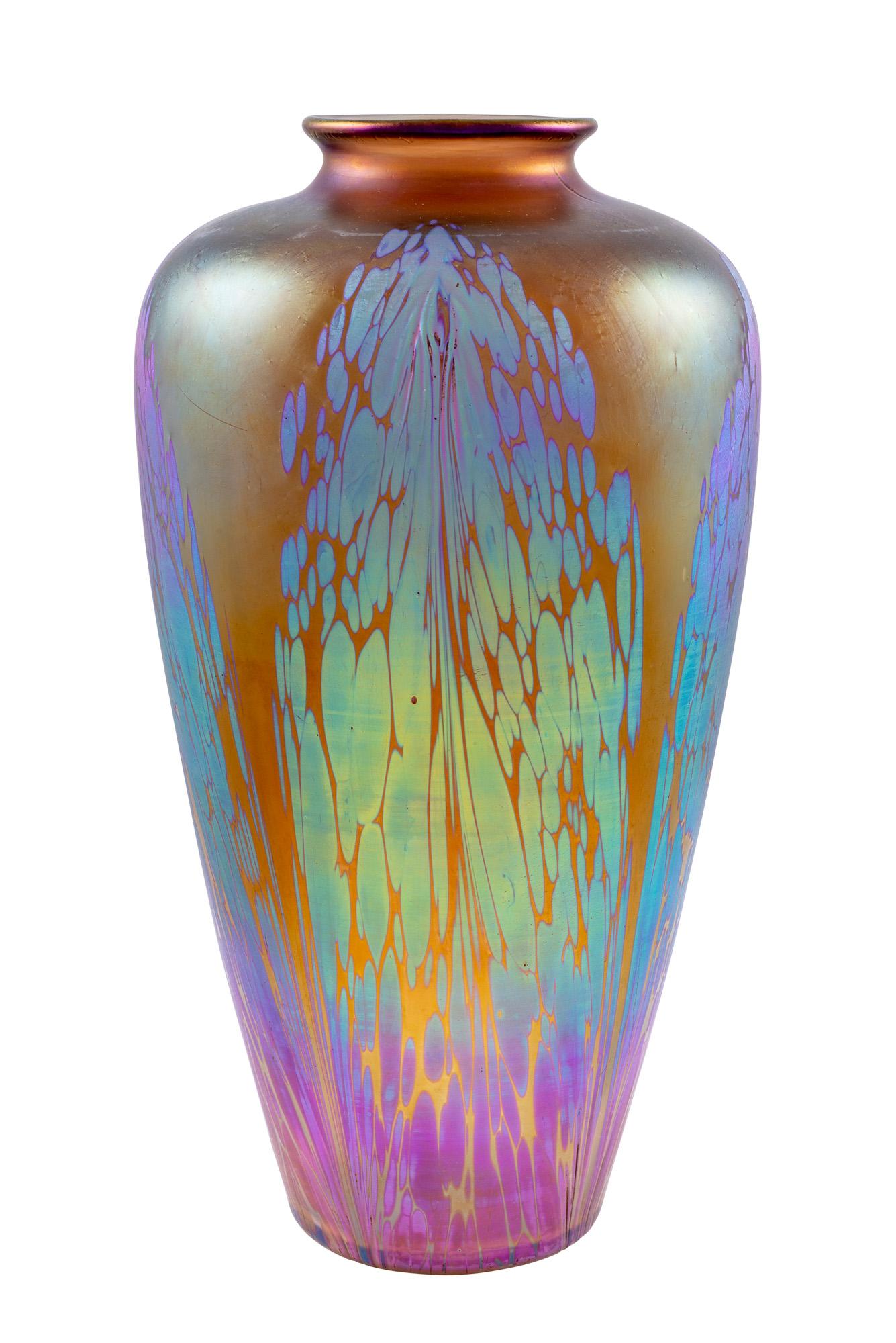 The decor variant Medici or Phenomen Gre 2/484 was very successful for the Loetz Company. The combination of strongly shimmering silver oxide tongues and bright colours met the taste of their customers precisely.

What is striking about this vase