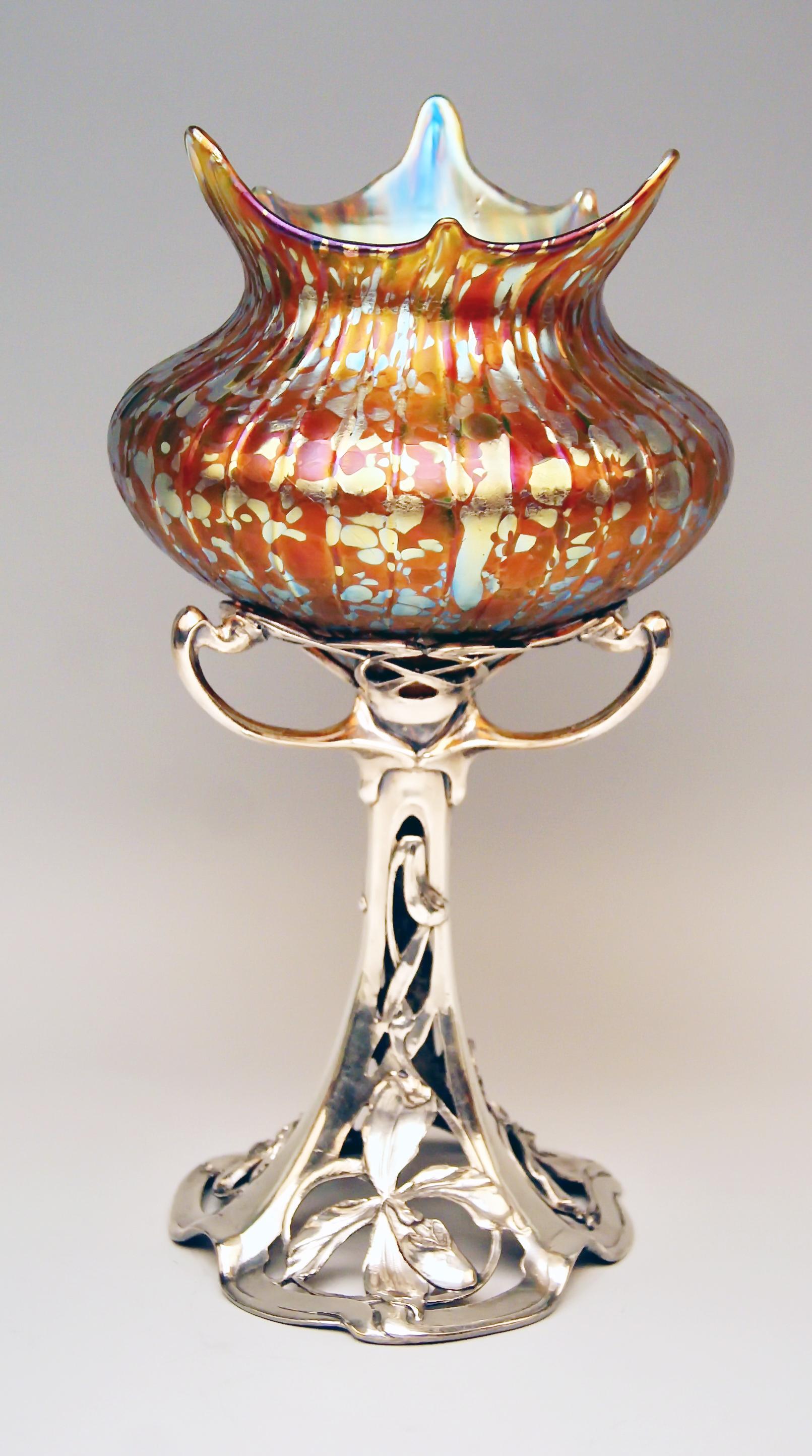 Gorgeous Art Nouveau Vase of very rare shape

Made by Loetz (Lötz) Widow Klostermuehle Bohemia, circa 1900
Decor: amber-orange colored type of Papillon
Form: round as well as bellied body with scalloped mouth and silver plated