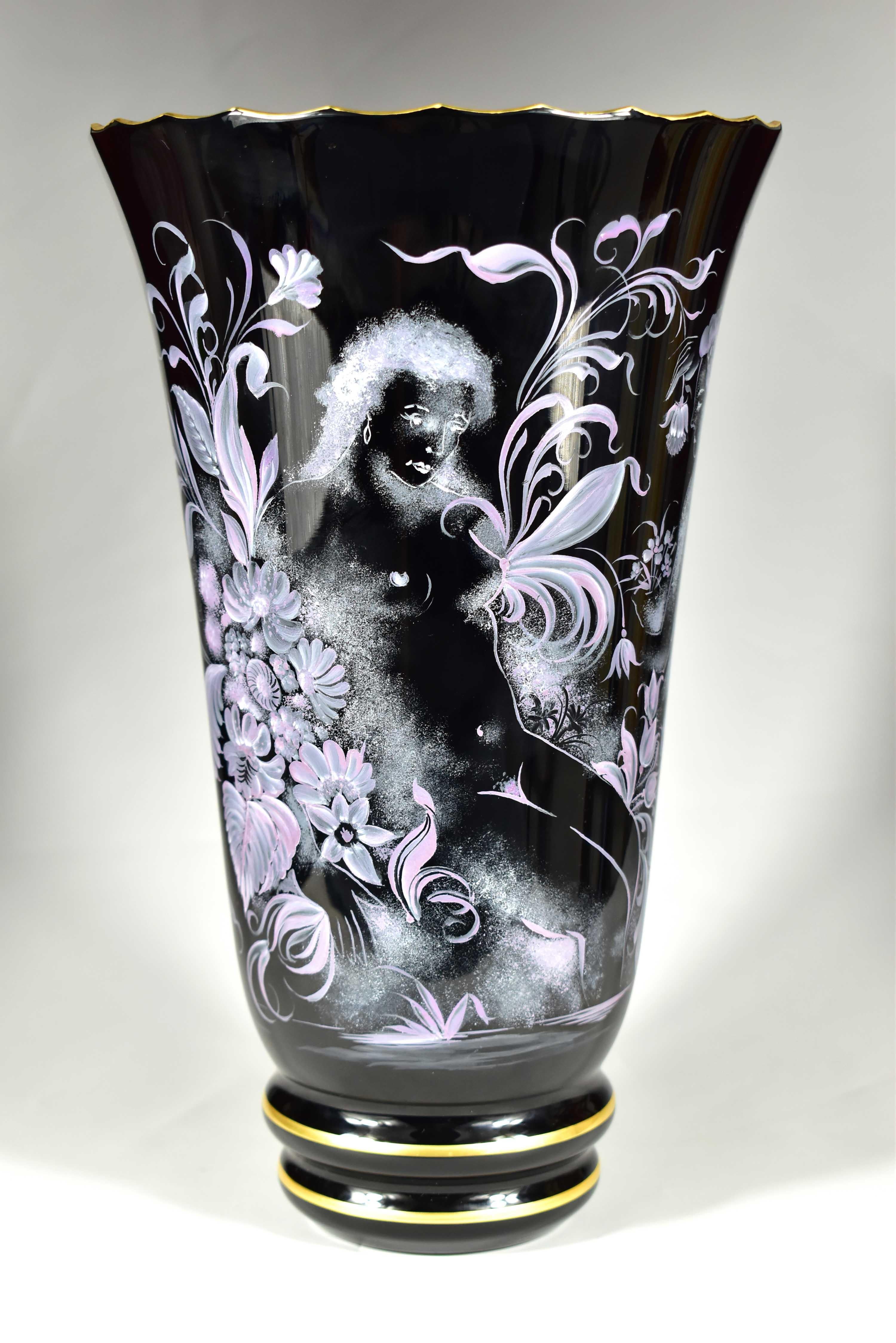 Se trata de un jarrón de cristal negro soplado y pintado a mano. La parte superior está cortada a mano. El cuadro es de estilo art déco, con un motivo de desnudos femeninos y un motivo vegetal. El jarrón no está dañado. Se trata de una bella obra de