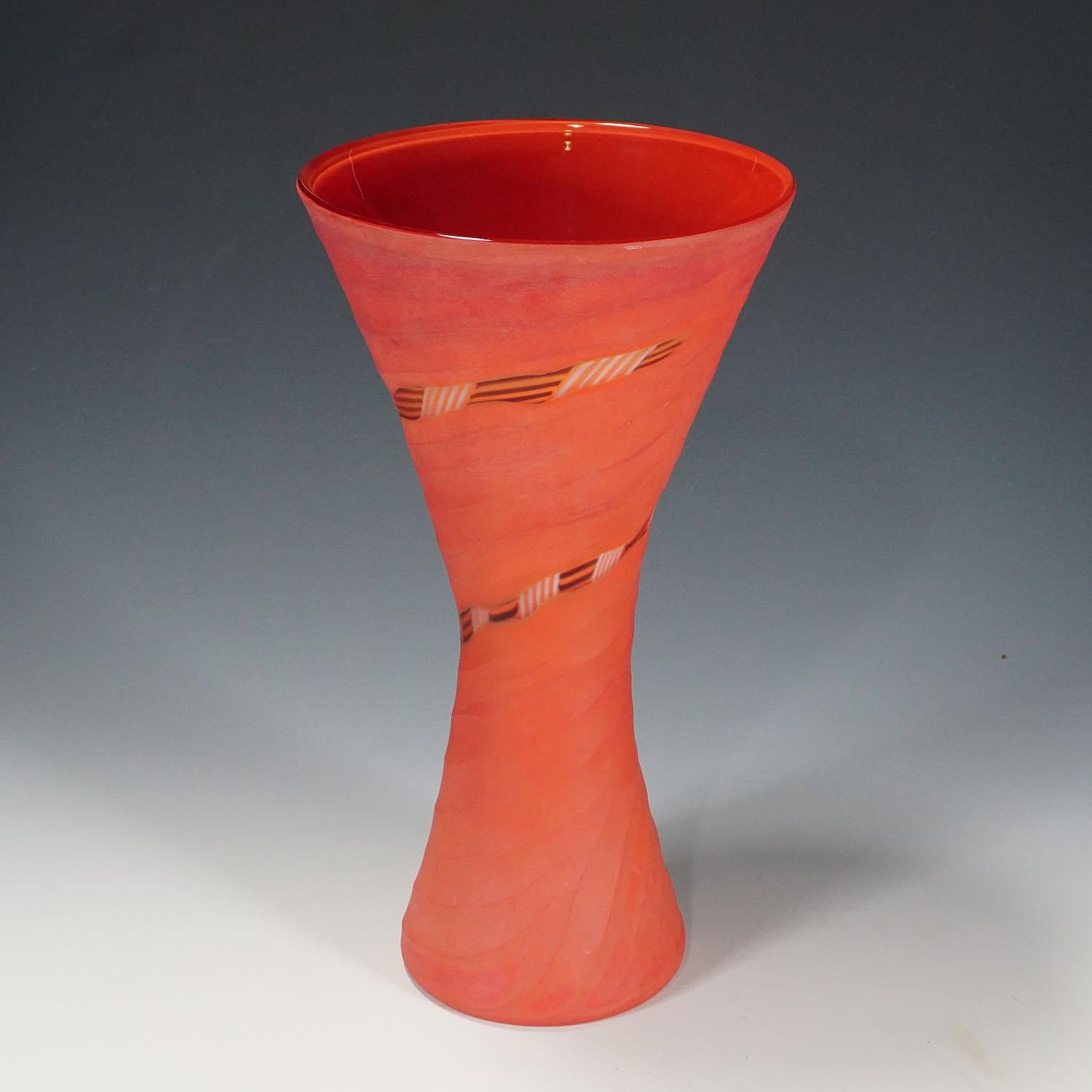 Eine Vase aus der Serie Manto, entworfen von Rodolfo Dordoni für Venini. Verschmolzenes korallenrotes, klares und schwarzes Glas, Oberfläche mit Mattschliff. Venini, Murano 2001. Mit Venini-Etikett und eingeritzter Signatur auf dem Sockel.

Maße: