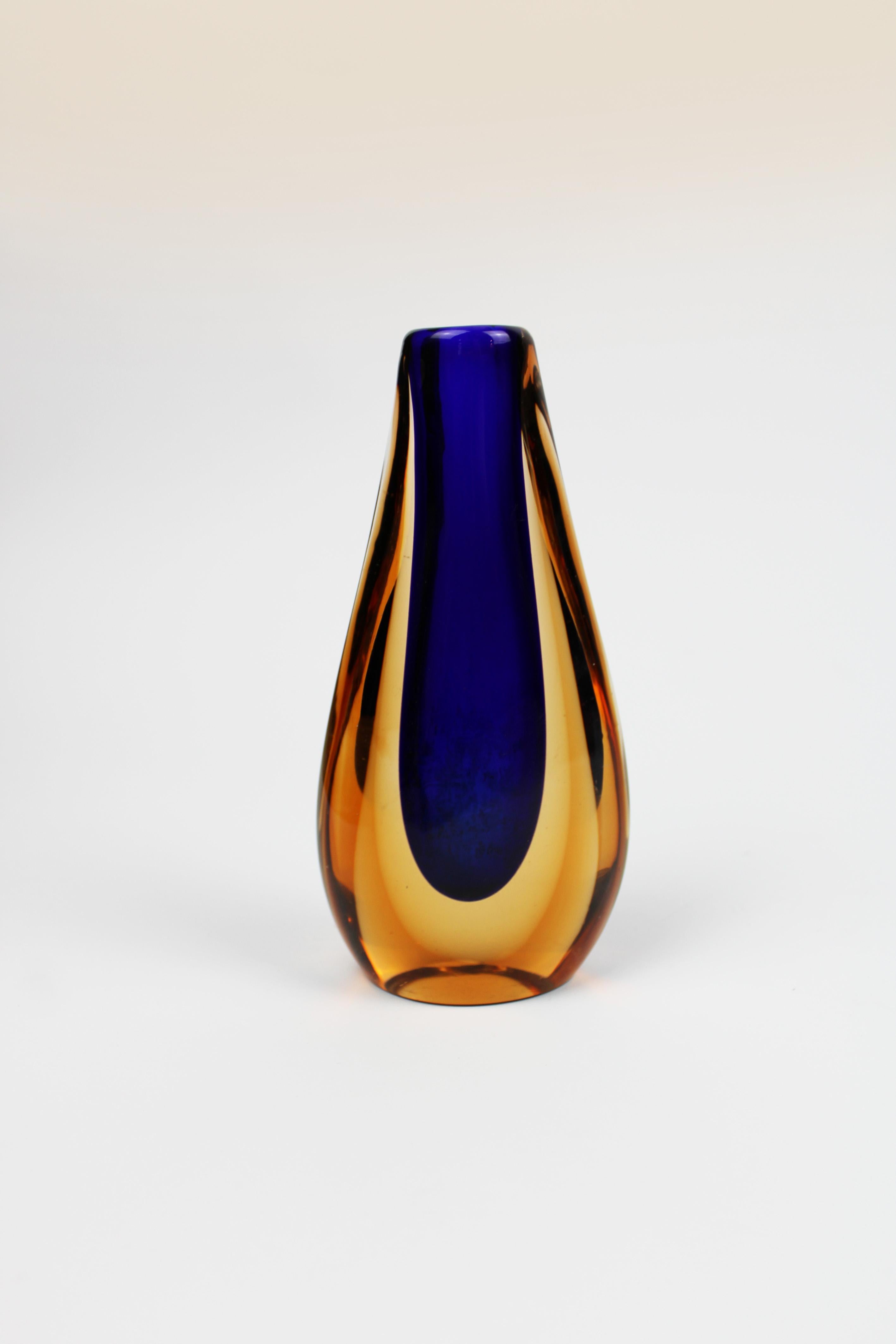 Presenting a stunning single flower vase from the 1970s, designed by the acclaimed Flavio Poli. Crafted from exquisite Murano glass, this vase features a striking blend of yellow and blue hues, capturing the vibrant artistry and exceptional