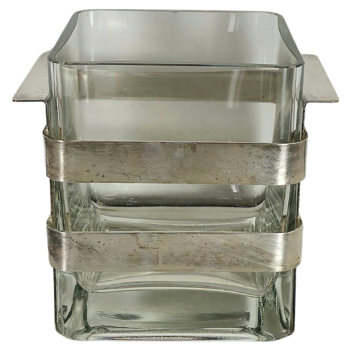 Seau en vase/glace fabriqué en Italie dans les années 70.
Vase de forme cubique en verre de Murano doublement transparent avec porte-vase en laiton nickelé. Veuillez regarder attentivement la vidéo et les photos, merci.

Mesures uniquement pour le