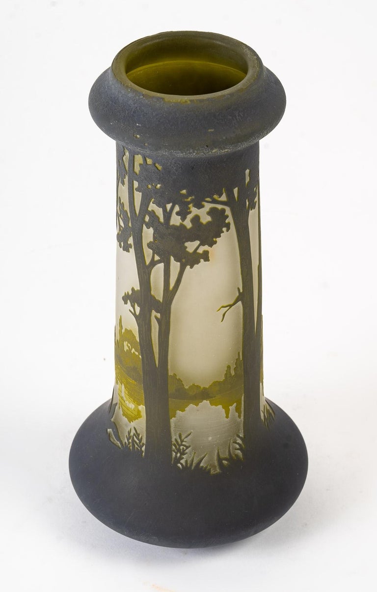 A pâte de verre vase with acid-etched decoration of a brown landscape on a green background, with an expanse of water surrounded by trees, groves and lake vegetation.

Period: Art Nouveau

Dimensions : Height : 25cm - Diameter of the base : 12cm