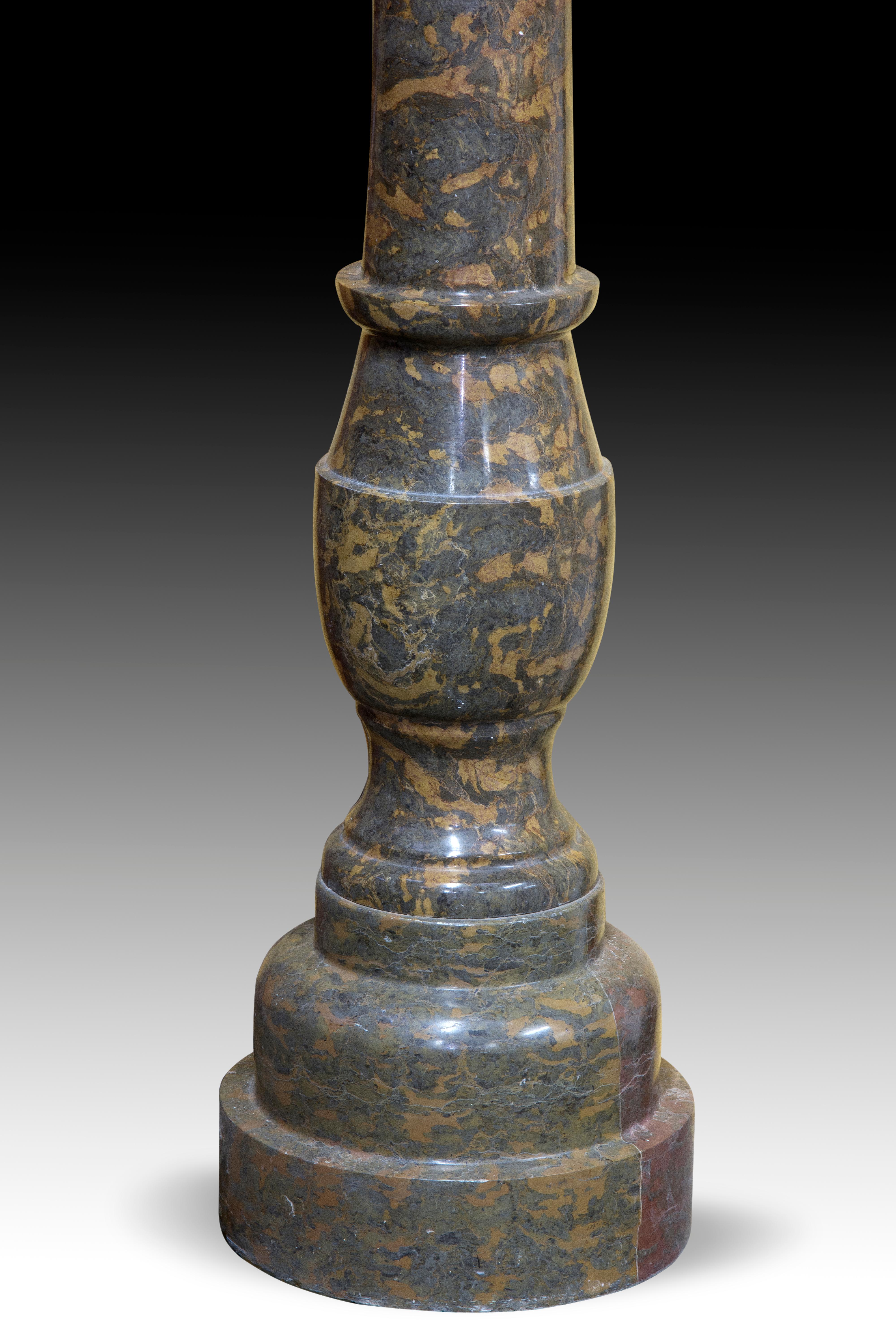 Both elements have been made using the same stone to provide uniformity to the work. The forceful base, the column, with a baluster, and the cup decorated with pronounced moldings respond to models related to Mannerism and Baroque. These types of