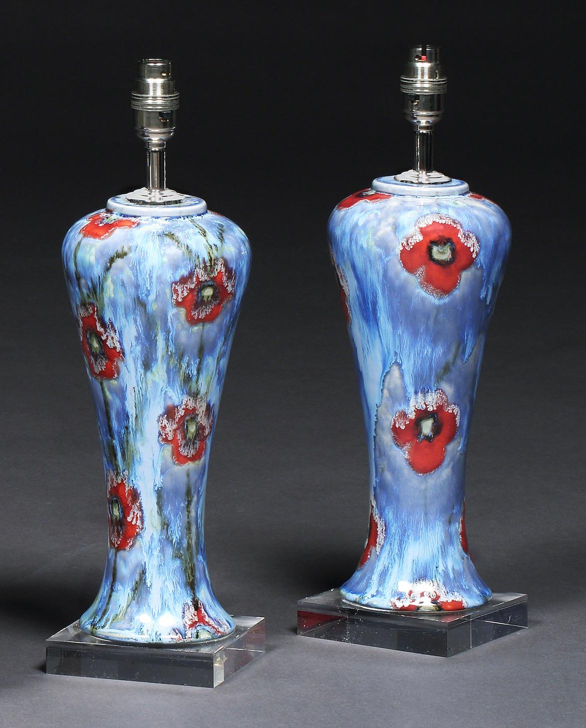 A pair of Cobridge, poppy & ice pattern, hand painted, table lamps on Perspex bases. Measures: 16 1/2” 42cm high to top of chrome fitting

One of Cobridge Pottery’s most popular patterns, designed by artist Anita Harris, leading designer at