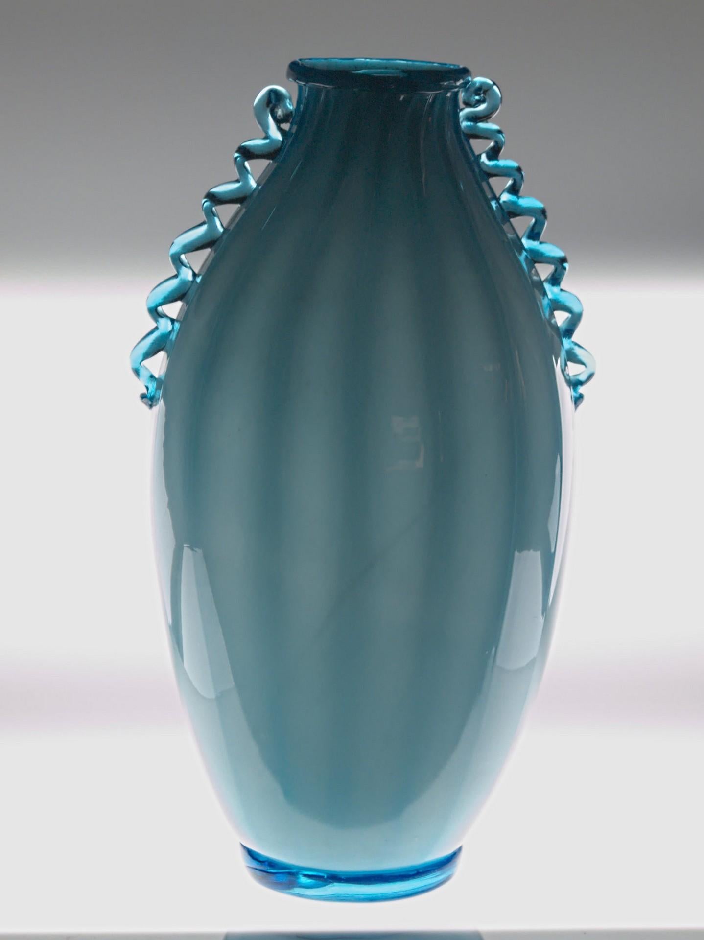 This vase shows many features that are on the Marinuzzi Zecchin vessel production. It's costolato sfumato with typical hansw handles and the curl at the upper end.

Has the costolatora in the same way of other vases and the typical morisa non