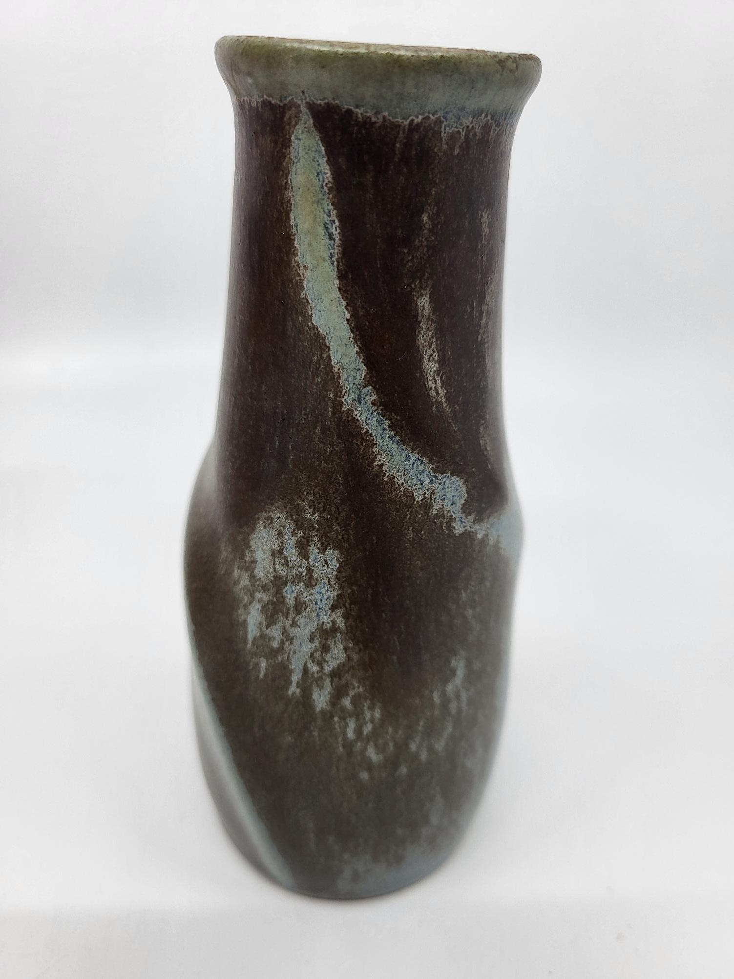 Il vaso Soliflores Denbac in céramique grès, emblematico dello stile Art déco degli anni 1920, testimonia l'eredità di René Denert, che fondò il suo atelier a Vierzon nel 1908. Ce dernier, forte dell'attività céramique che prospera nella città fin