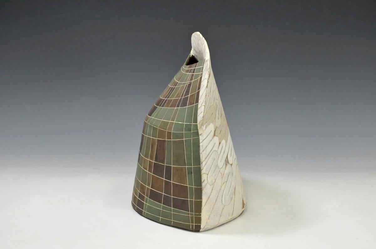 This sculptural vase, titled “Nuage” unique piece, crafted around 1980, exemplifies the remarkable skill of Japanese ceramicist Watanabe Nobuo in slab construction and inlay techniques.

Born in 1949 in Niigata Prefecture, Watanabe began his