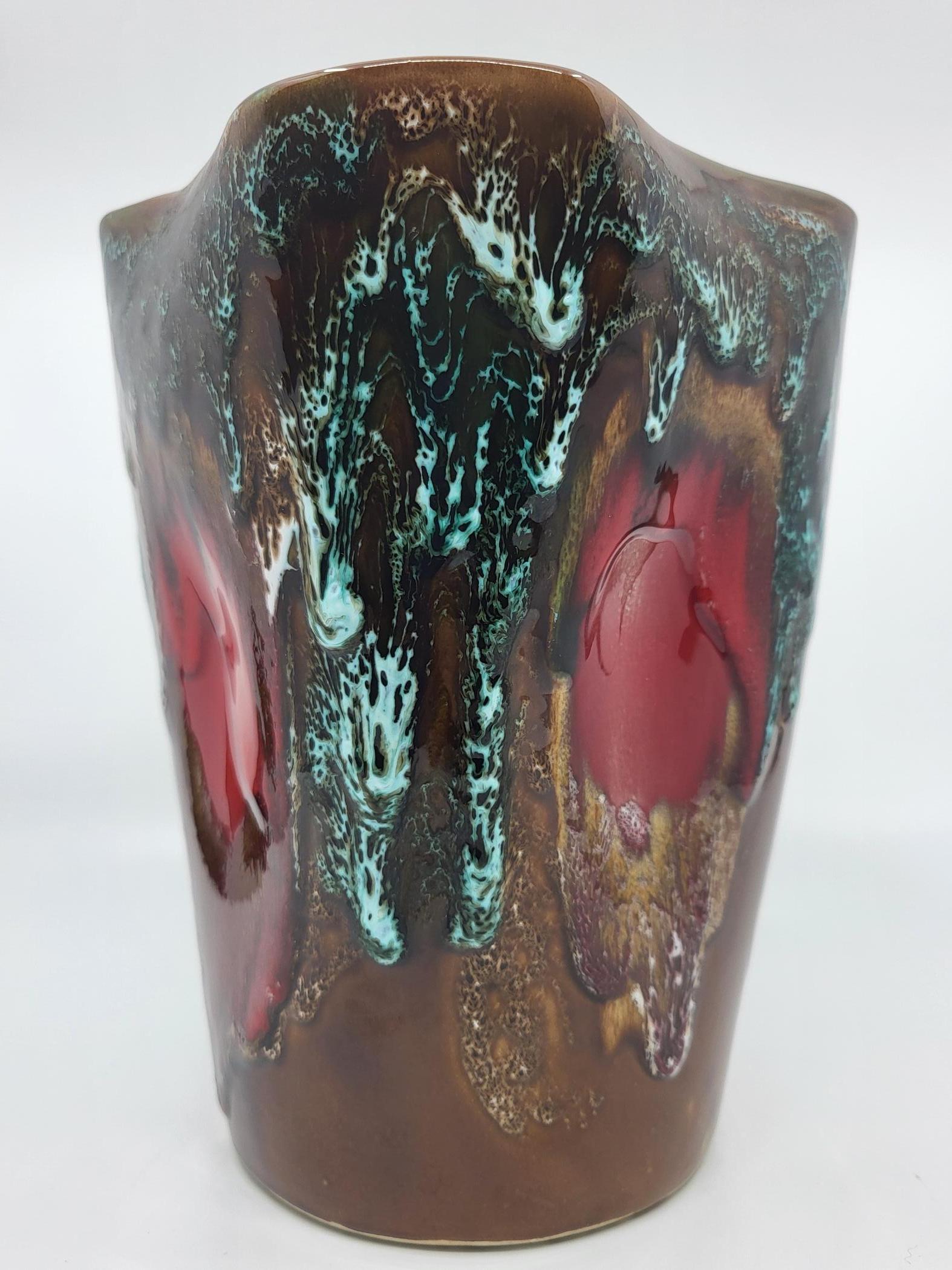 Vase Vallauris avec les couleurs dominantes, marron, bleu et rouge en forme de trèfle à 4 feuilles. Subtil mélange d'émaux colorés qui ont gardés toute leur brillance. Fait à la main .
Il fut crée à 