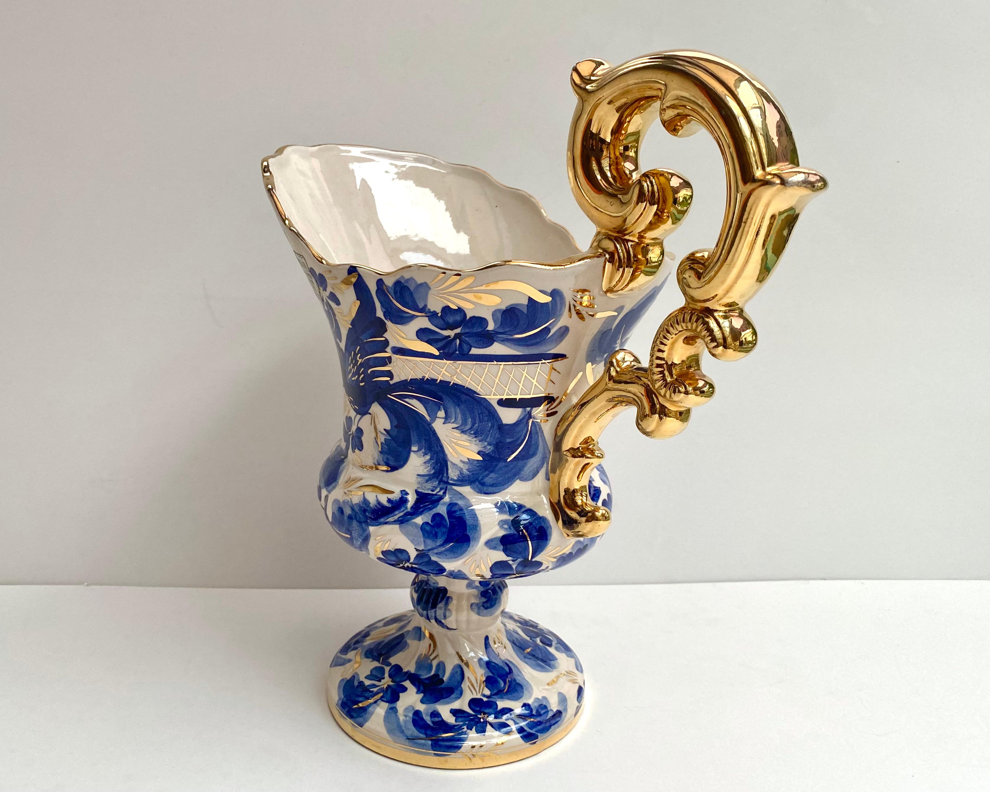 Gorgeous Hubert Bequet ceramic pitcher vase with a beautifull hand painted blue pattern. 

Decorated with 24K gold.   Belgium,  1960s.  

All hand crafted and hand painted.  

All accents in gold including the scroll handle and neck “cut