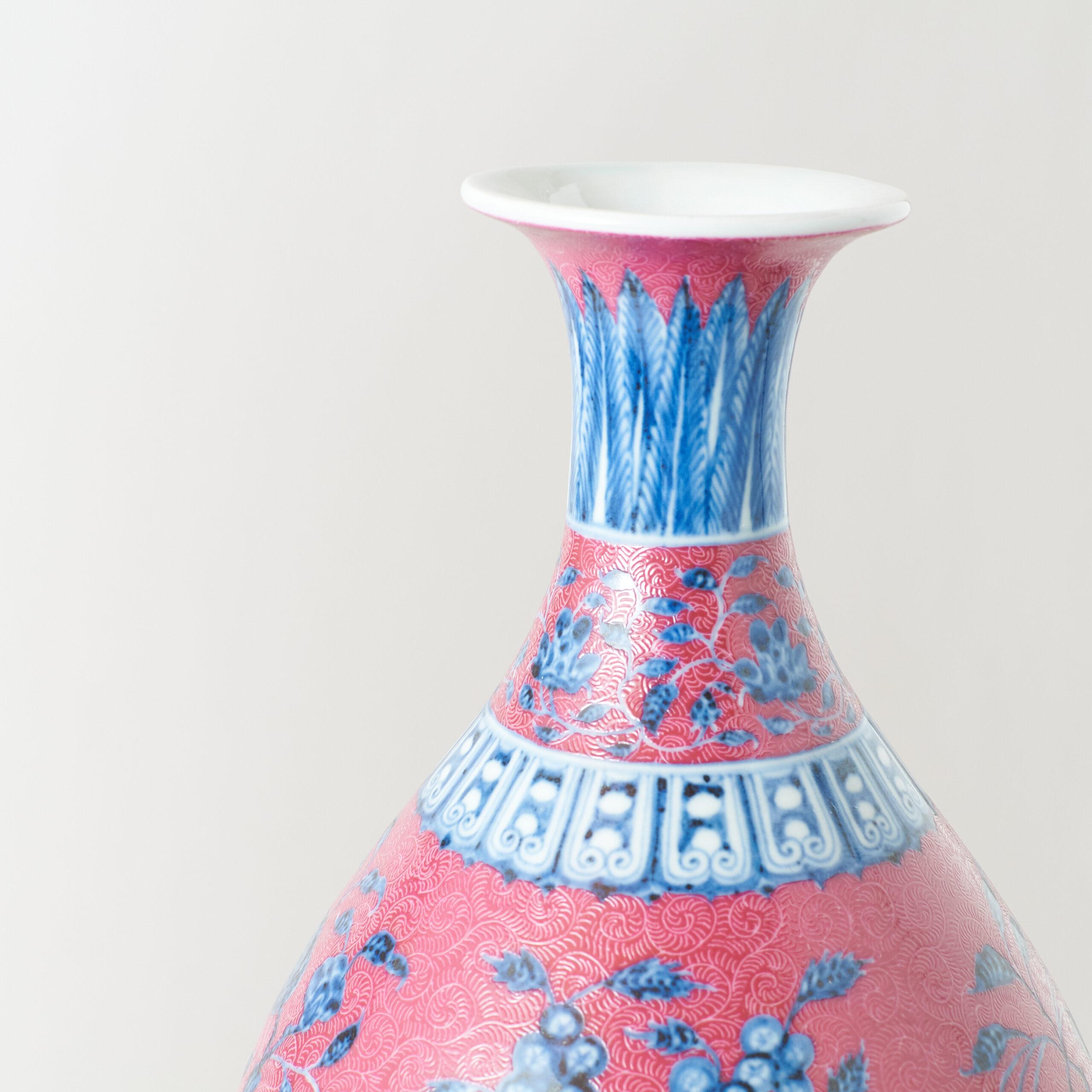 Jarrón con decoración de lotos azules y blancos sobre fondo rosa, marcado Xuande

Jarrón de porcelana con fondo rosa intenso, flores de loto blancas y azules bajo vidriado y follaje en volutas. Las bandas decorativas incluyen un patrón de grecas en