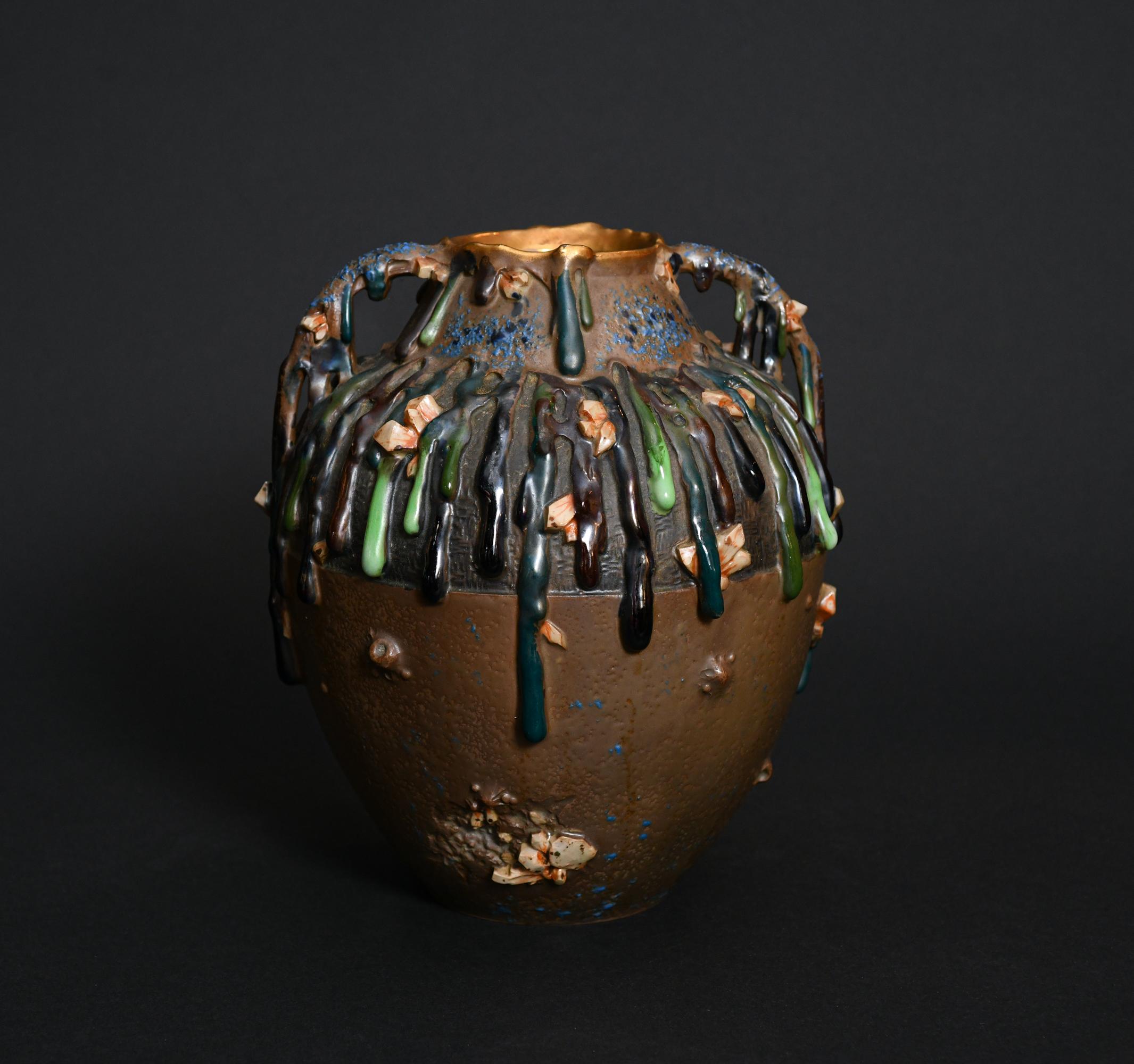 The virtuosic blending of color and texture shows how inventive decoration can triumph over nondescript form. Brightly colored drips of slurry clay cascade like melted wax down the two-handled jug-like body, whose shoulder and lower body exhibit