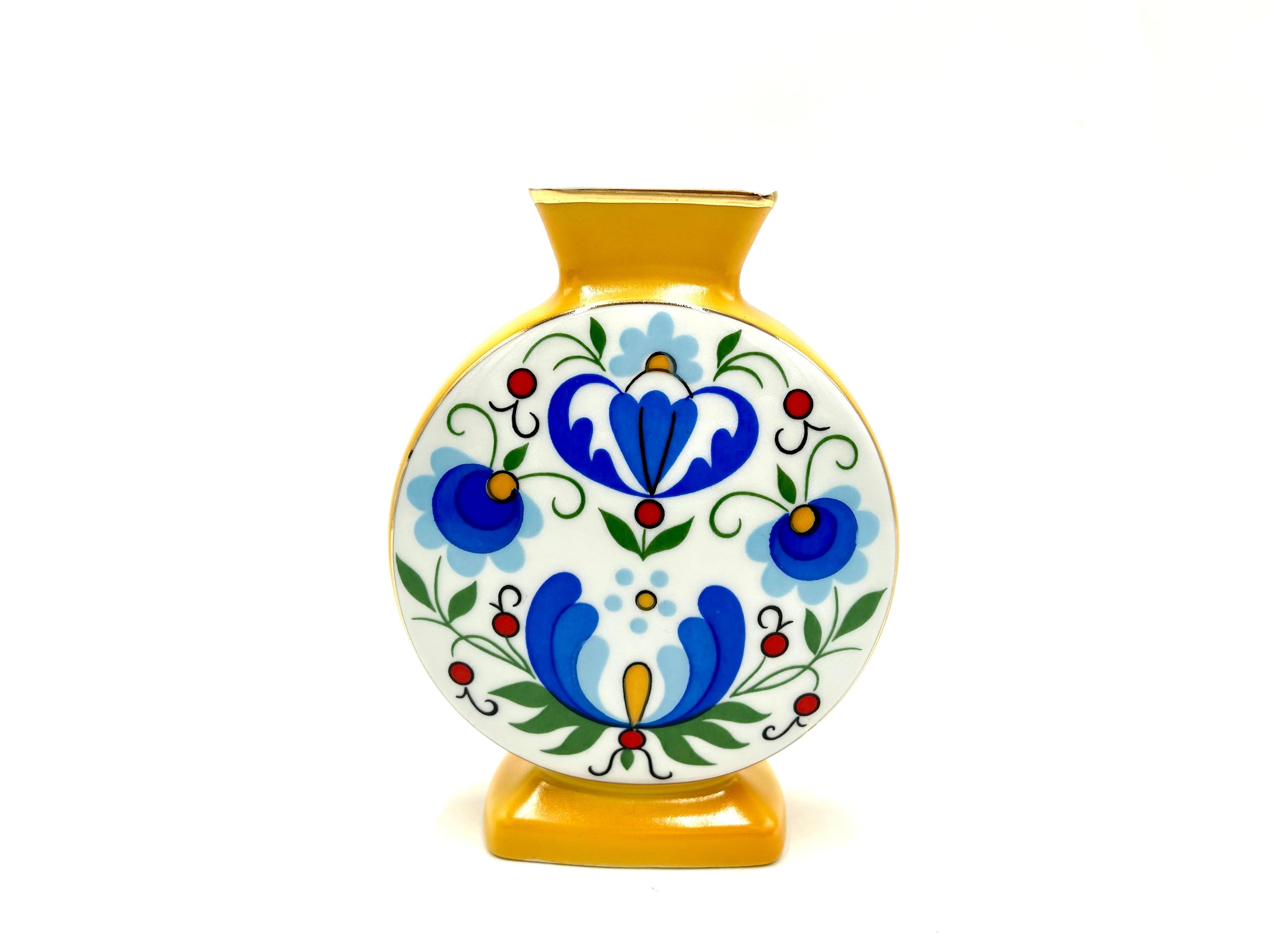 Eine kleine Vase mit volkstümlichen Mustern

Produziert in Polen von Zakłady Porcelany Stołowej Lubiana

Sehr guter Zustand ohne Schäden

Höhe 16cm Breite 12cm Tiefe 4cm