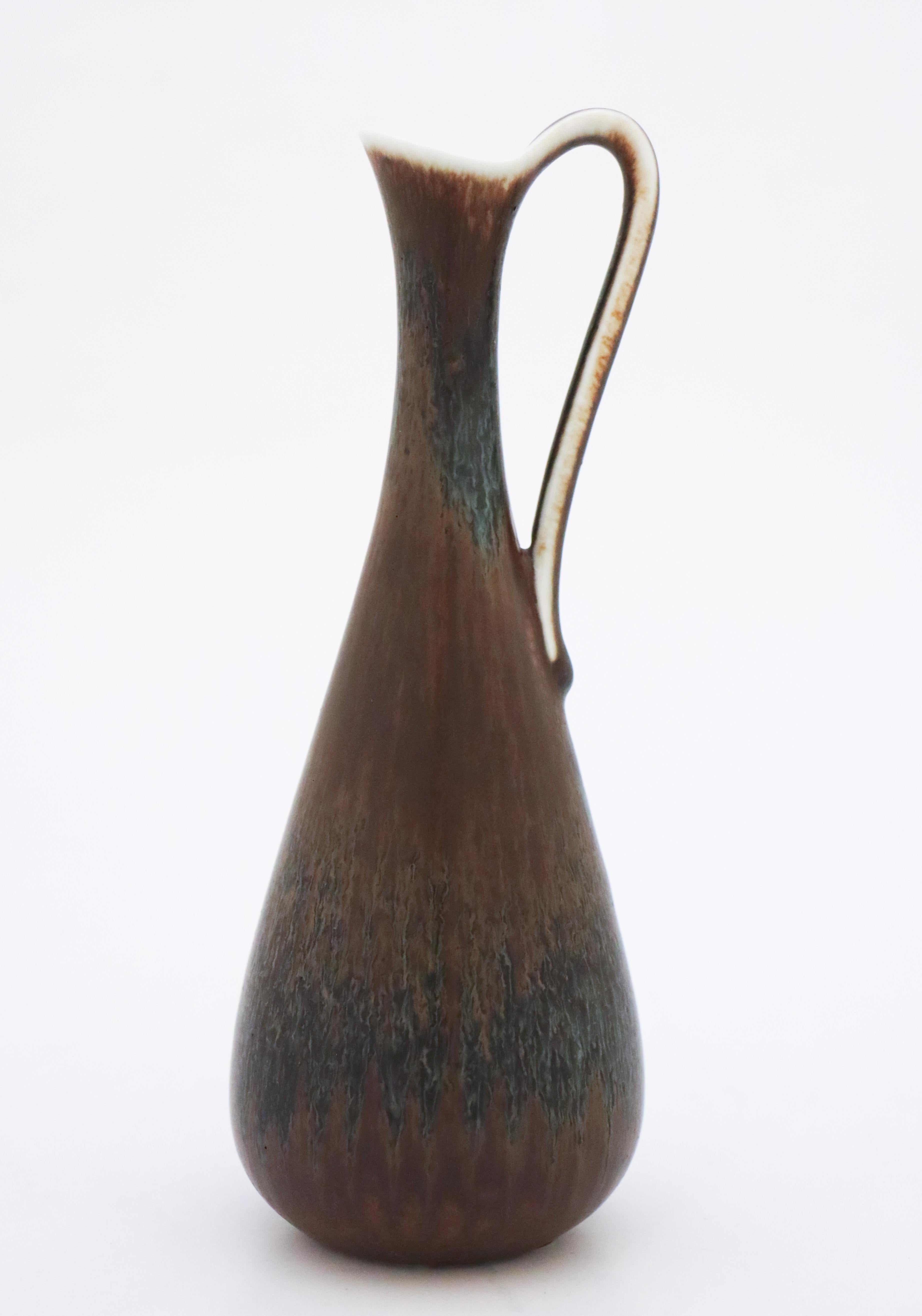 A lovely black and brown vase with handle designed by Gunnar Nylund at Rörstrand, it´s 20.5 cm high and it has a lovely brown & black har fur glaze, it´s in excellent condition and marked as 1:st quality.

Gunnar Nylund was born in Paris 1904 with