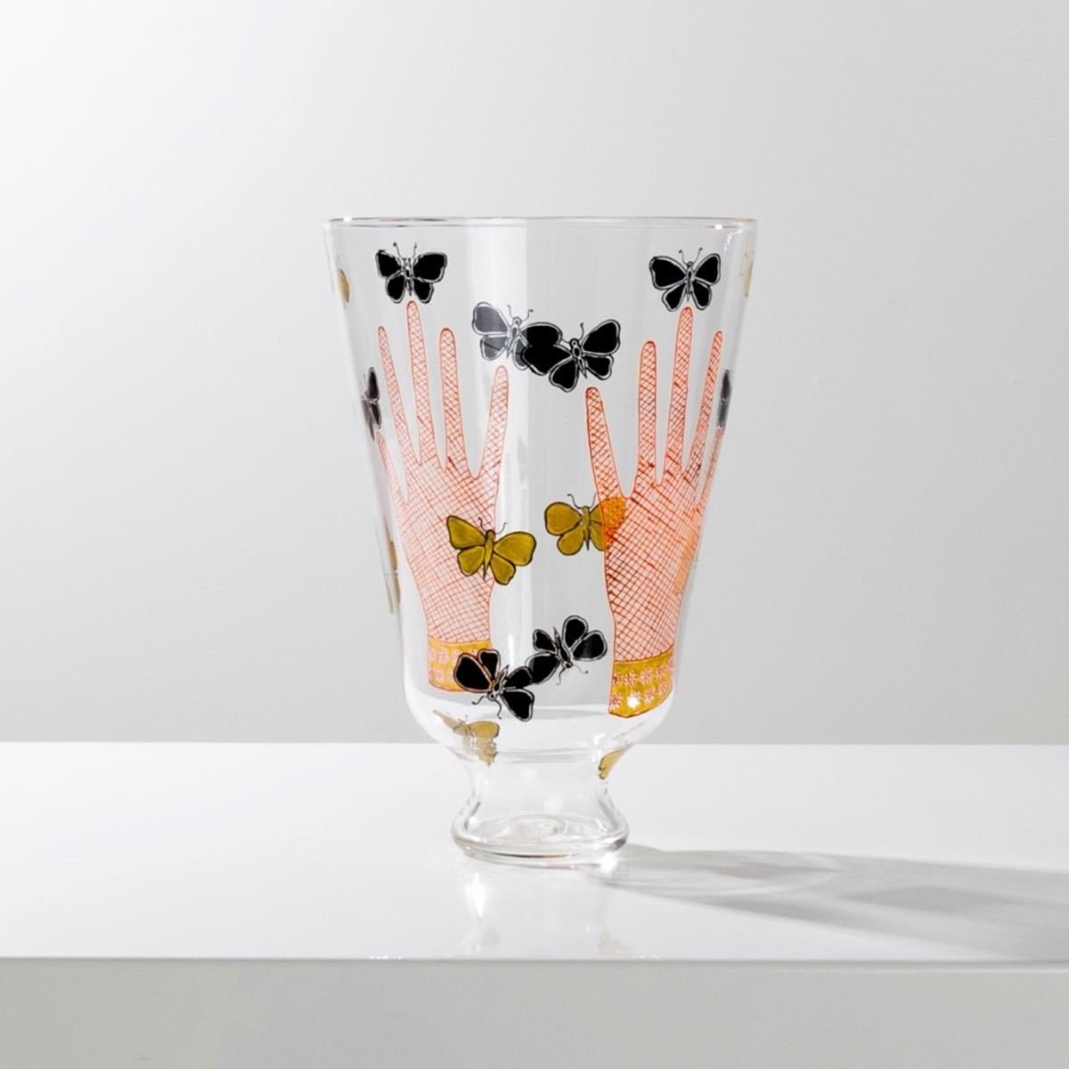 About this vase with hands and butterflies (Mani con Farfalle a Smalti vase) by Piero Fornasetti
Transparent blown glass vase on a pedestal.
The vase is entirely enamelled by hand.
It is decorated with drawings of two hands surrounded by