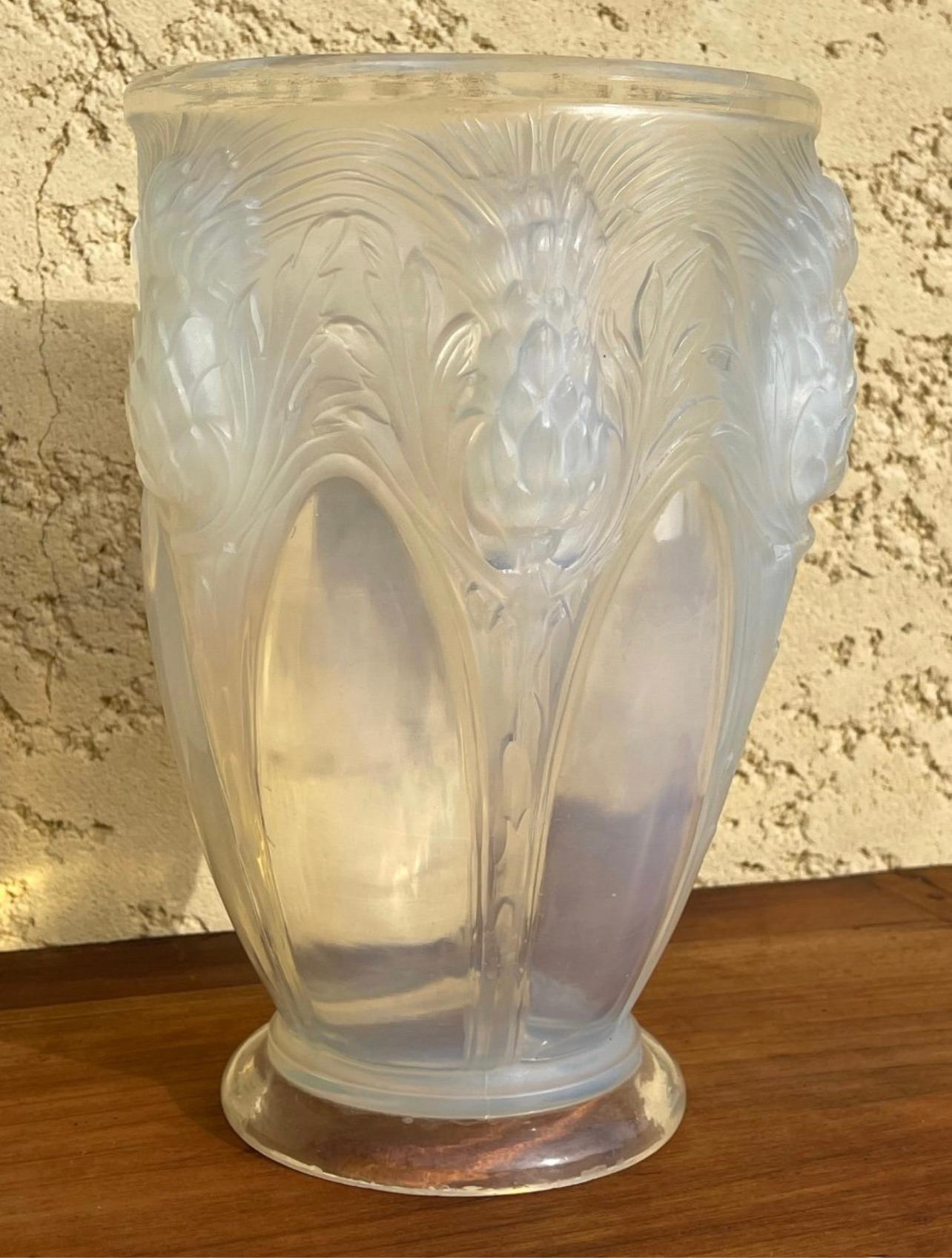 Vase en verre moulé et pressé bleu opalescent décoré de chardons signé Verlys France sous les pieds du vase. Il est en très bon état.

Dimensions
Hauteur : 25 cm
Diamètre du col : 16 cm