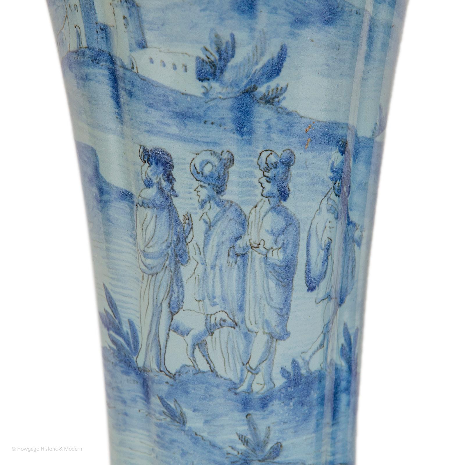 Tapered. The shaped tops and feet with borders of acanthus leaves. One vase depicting men and a dog walking in hilly medieval landscape, the other with crusaders fighting. The bottoms have been drilled, suggesting that they were used to display