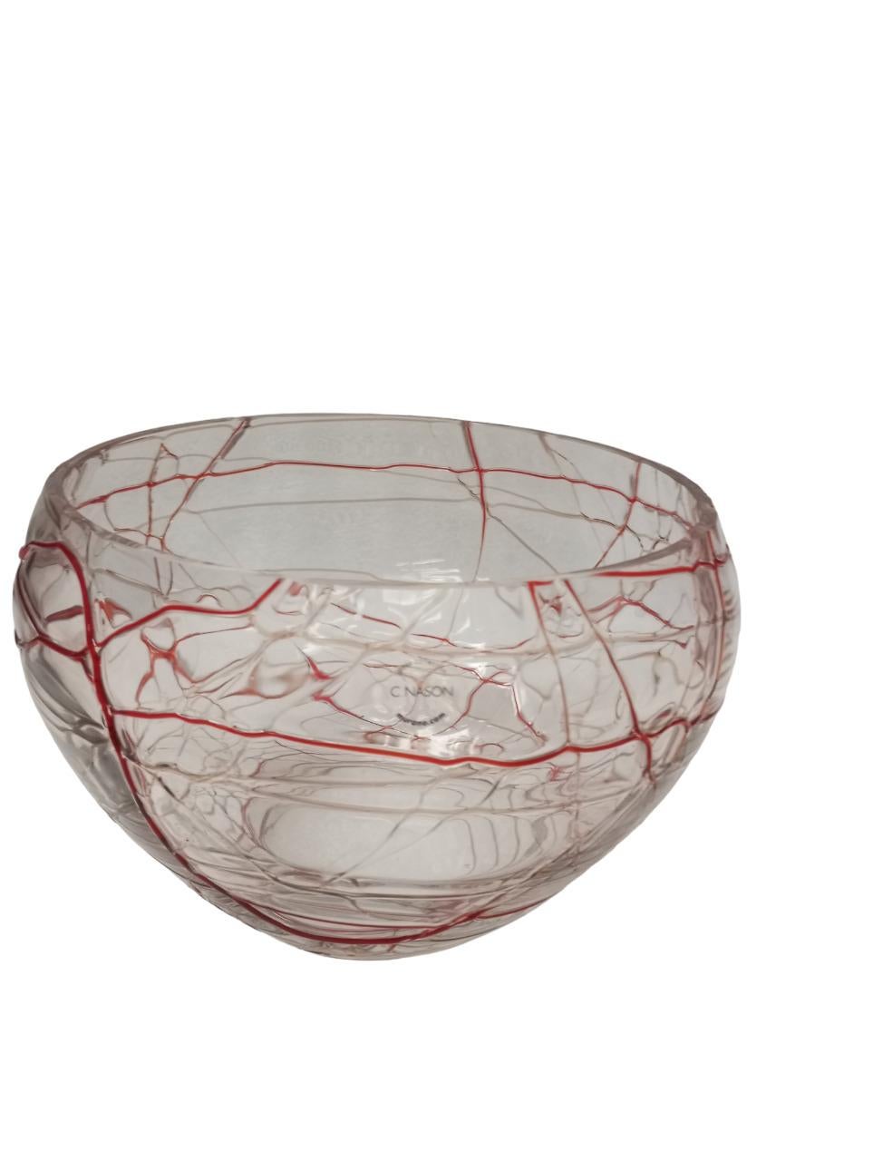 Raffinata ciotola in vetro soffiato con inclusione di filamenti in lattimo, nei toni del rosso su vetro trasparente, disposti in modo irregolare a creare un elegante motivo decorativo. L’effetto di trasparenze e intrecci cromatici conferisce