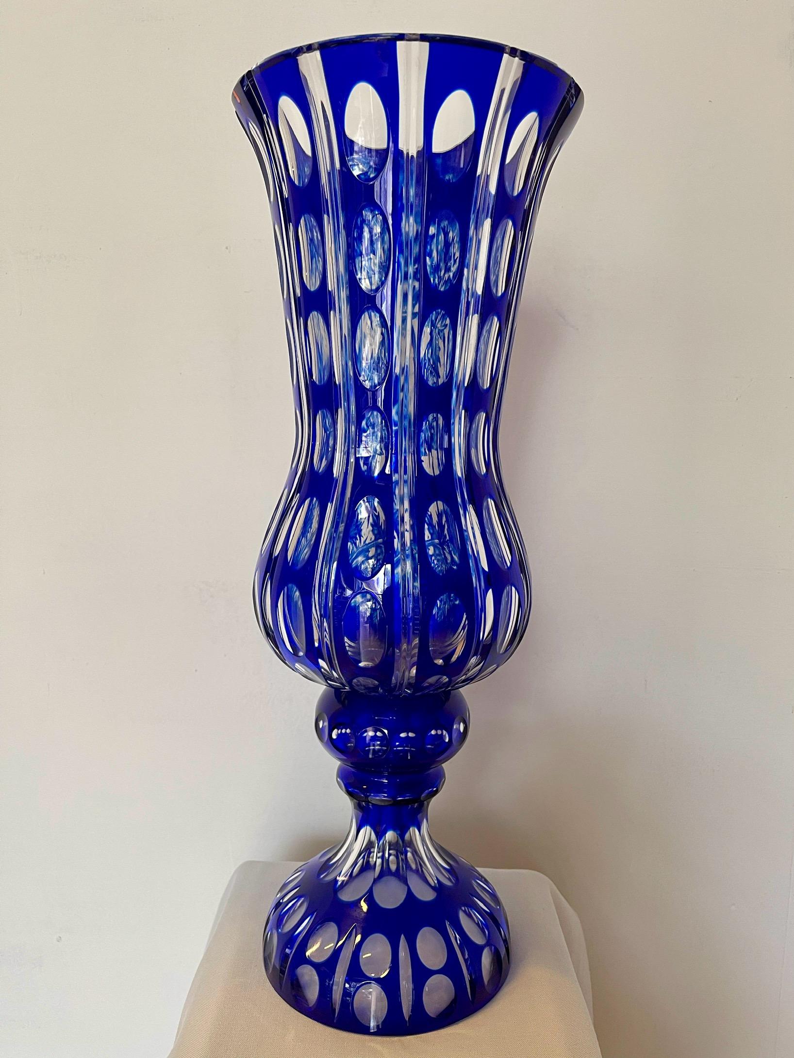 Splendido vaso decorativo realizzato in pregiato cristallo blu cobalto, caratterizzato da una lavorazione artigianale di altissima qualità. L’opera combina due tecniche artistiche: incisione a mano con motivi floreali raffinati su un lato e intagli