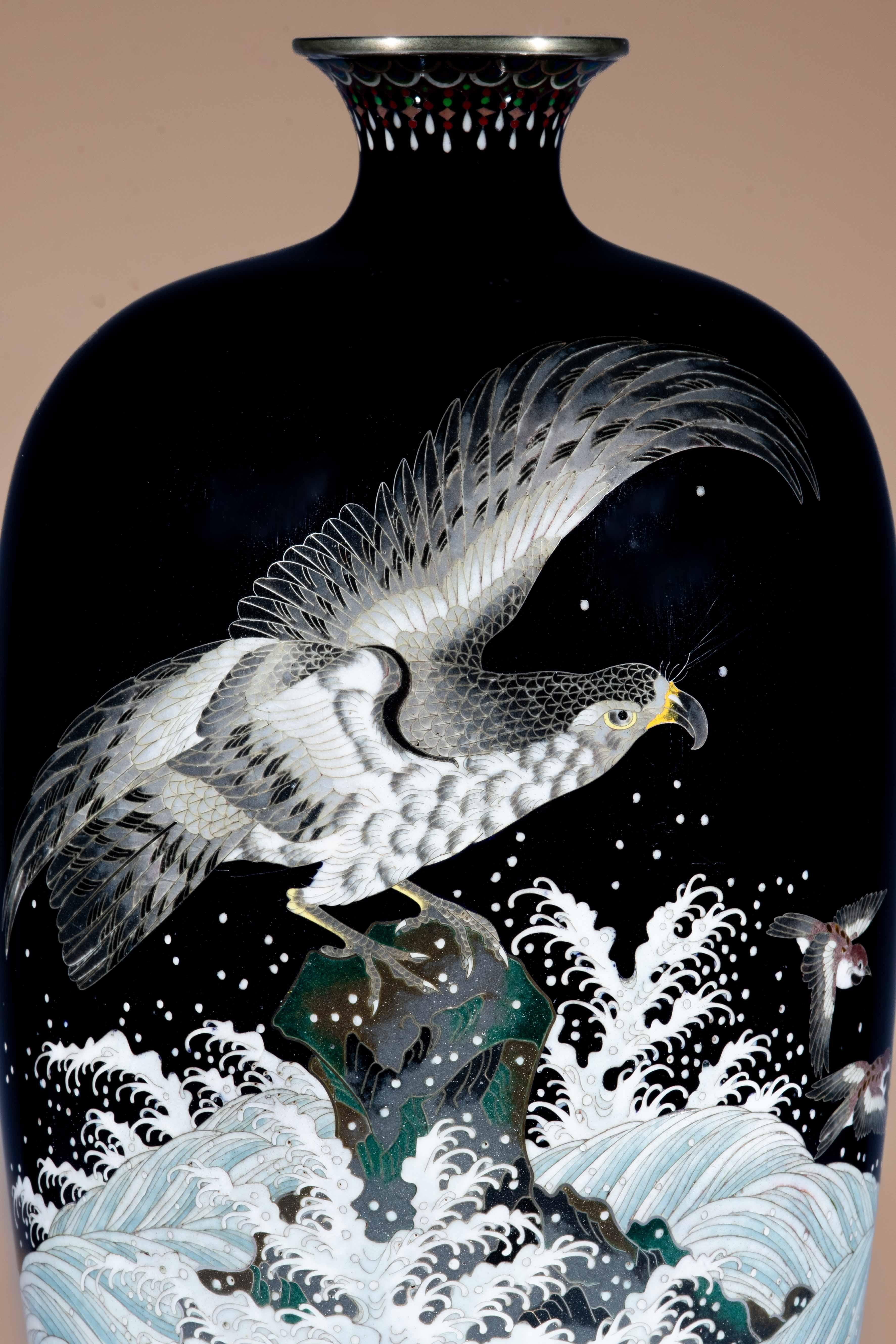 Vase décoré d'émaux cloisonnés polychromes sur fond bleu nuit, travaillé au fil d'argent représentant un aigle perché sur un rocher observant des chidori s'enfuyant sur des eaux tumultueuses. Le col et le pied sont décorés d'une bande de motifs
