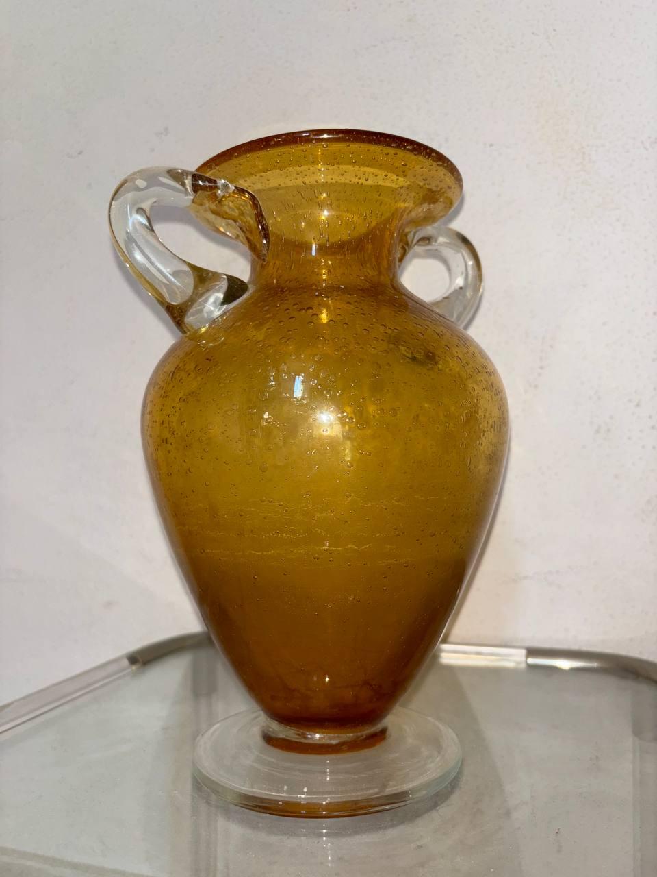 Vaso Barovier & Toso, nelle sue caratteristiche il vetro esprime delle bolle intorno tutto il vaso, essendo lavorato a mano dai grandi maestri possiamo notare un bolla un pò piu' grande di tutte le altre.
Vetro che rispecchia l'eta' del xx secolo,