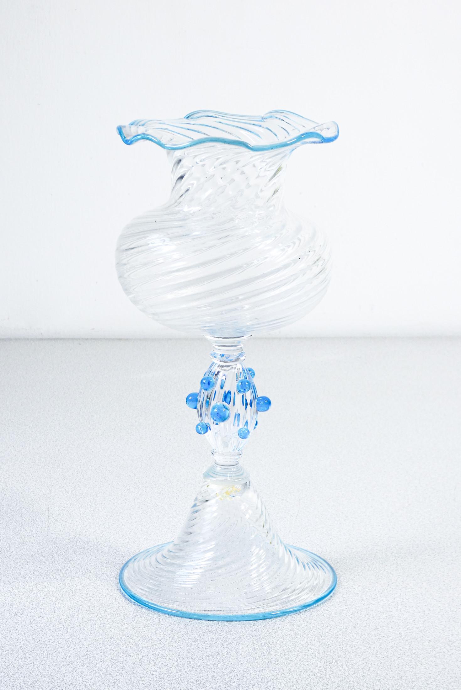 Vaso, coppa
in vetro soffiato
di Murano.

PERIODO
Anni 60

AUTORE
Pezzo interamente realizzato a mano, da maestri vetrai muranesi

MATERIALI
Vetro soffiato di Murano

DIMENSIONI
Altezza: 27 cm
Ø 11.5 cm

CONDIZIONI
Perfette. Valutare attraverso le