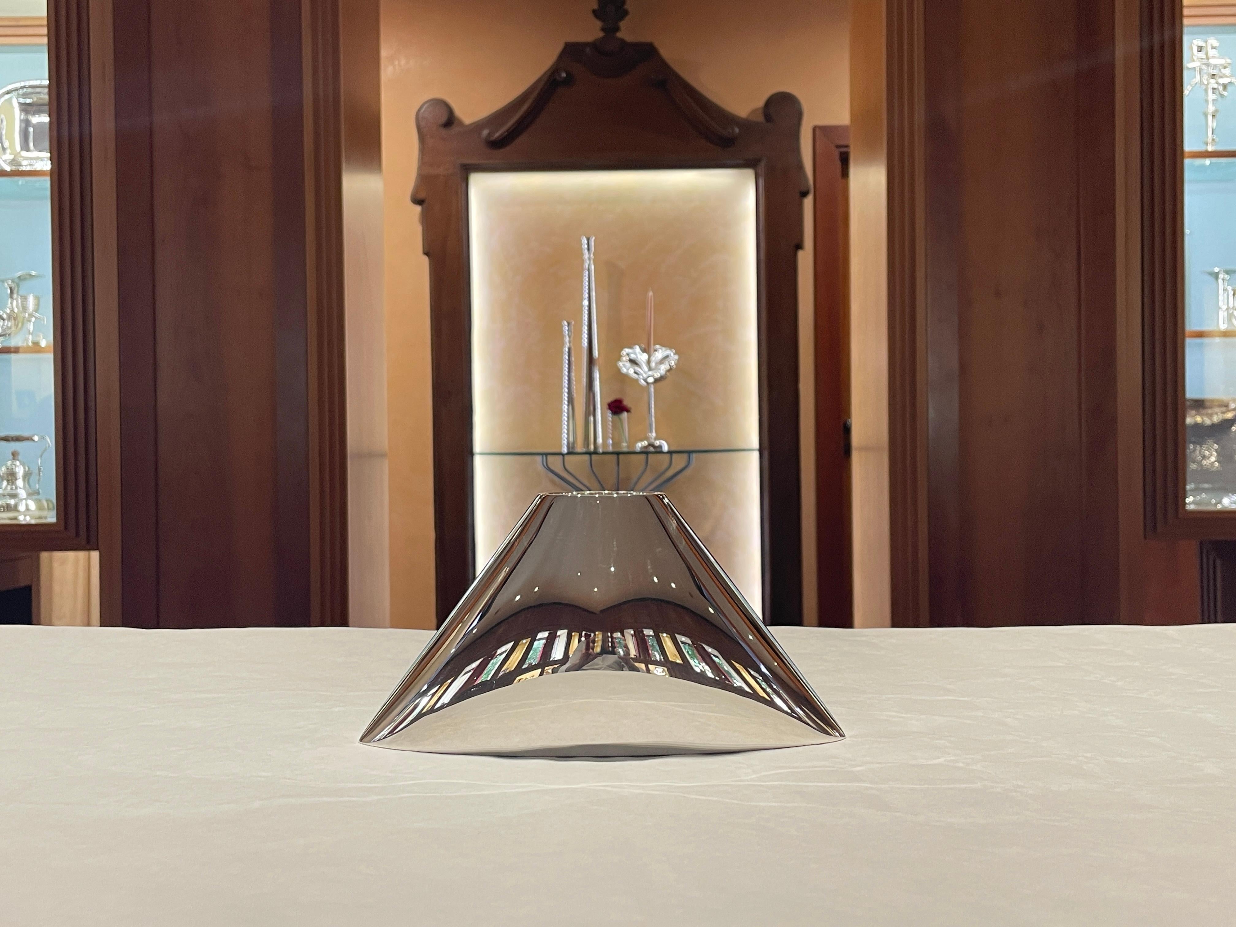 Vaso De Vecchi Milano 1935 in argento sterling 925
Altezza 11 cm
Base 21,5 x 8 cm
Peso 465 g
Referenza DM07

L’argento è uno specchio. Le immagini dell’ambiente si riflettono sulla superficie dell’oggetto, rendendo ambigua la percezione della forma.