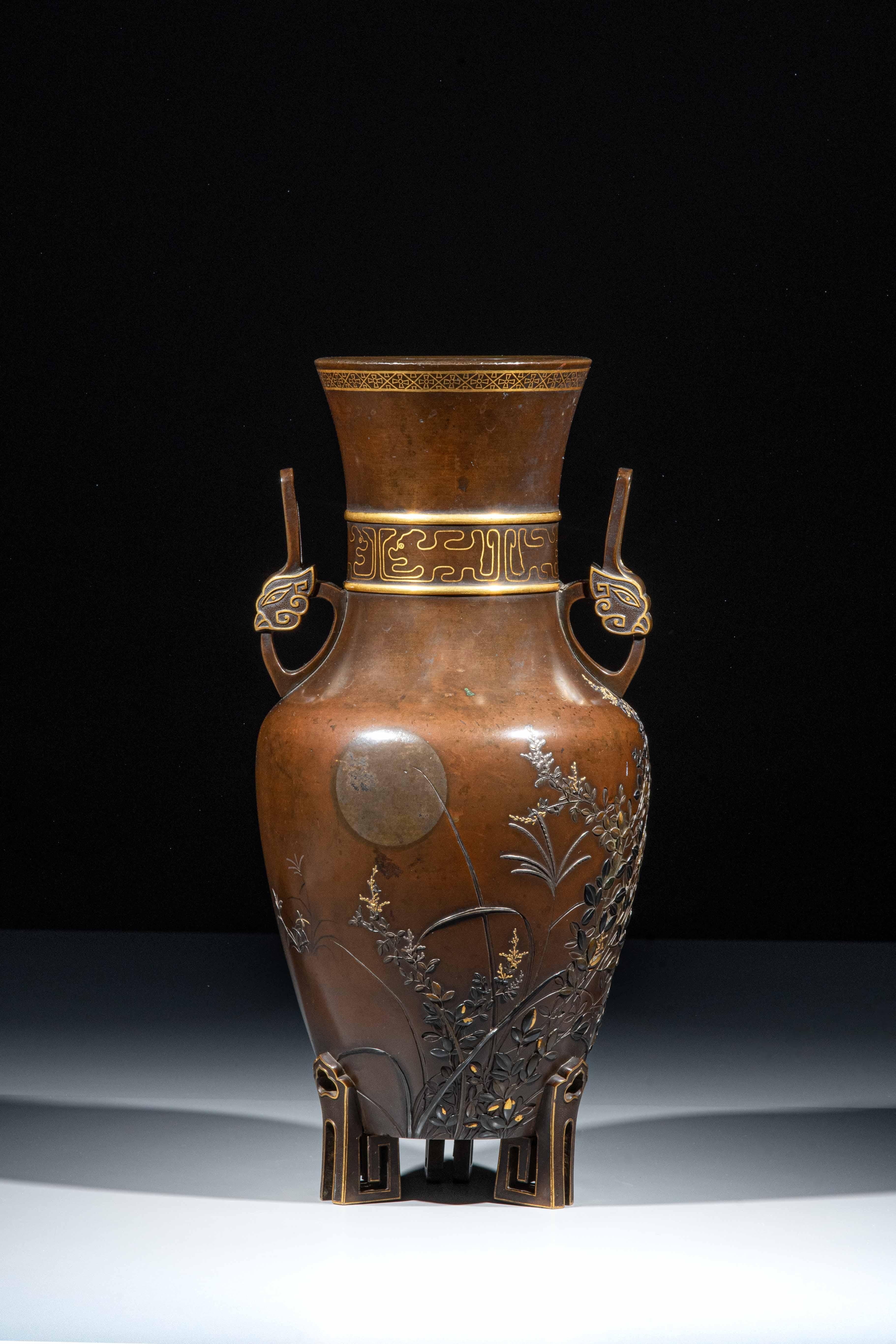 Vase amphore en bronze patiné représentant un lapin sculpté en takabori au milieu de branches luxuriantes éclairées par la lune, avec des incrustations en or iro-e takazogan, shibuichi et shakudo attribuées à l'atelier Takaoka de Kanazawa. Le col,