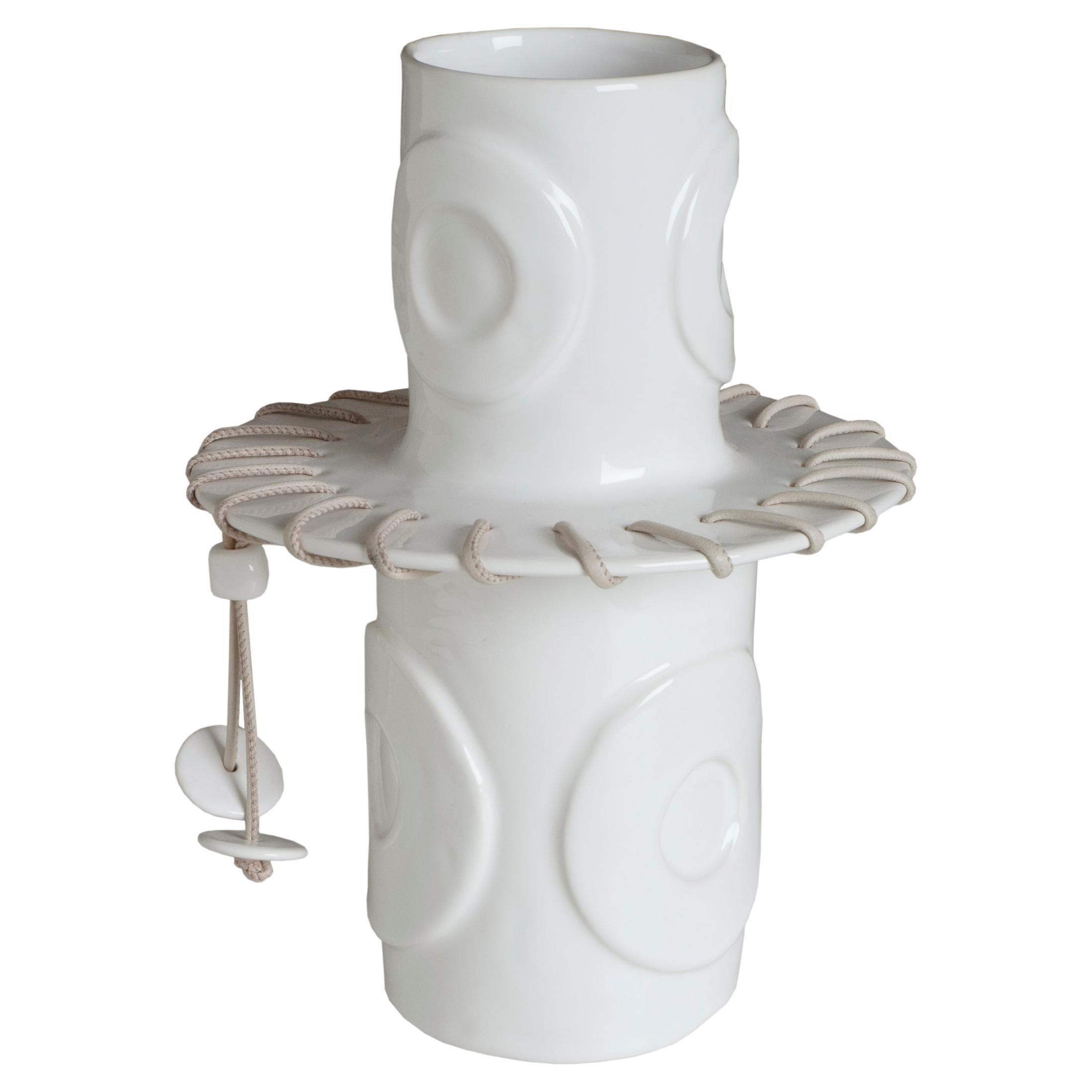 Vase en céramique blanche décoré en relief avec un cordon en cuir.