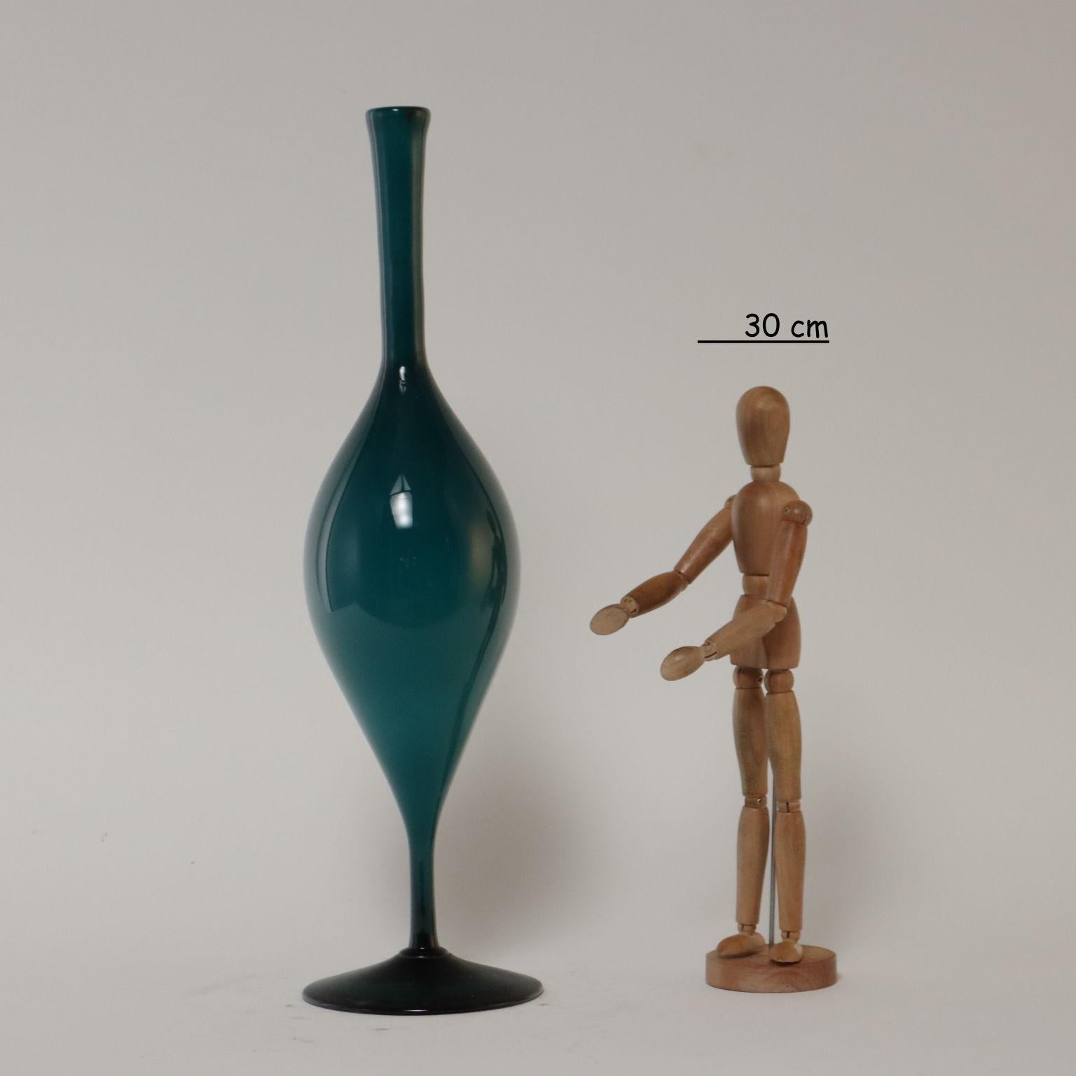 Green-colored encased glass vase with circular base and long narrow neck.