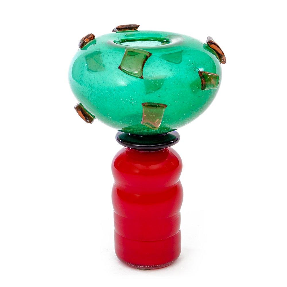 Vaso Donna Luisa di Herbert Jakob Weinand e prodotto nel 1985. Il vaso è interamente in vetro lavorato a mano e prodotto da Compagnia Vetraria Muranese, per Memphis Extra. 
Base color rosso con silhouette curva; bocca color verde con decori in