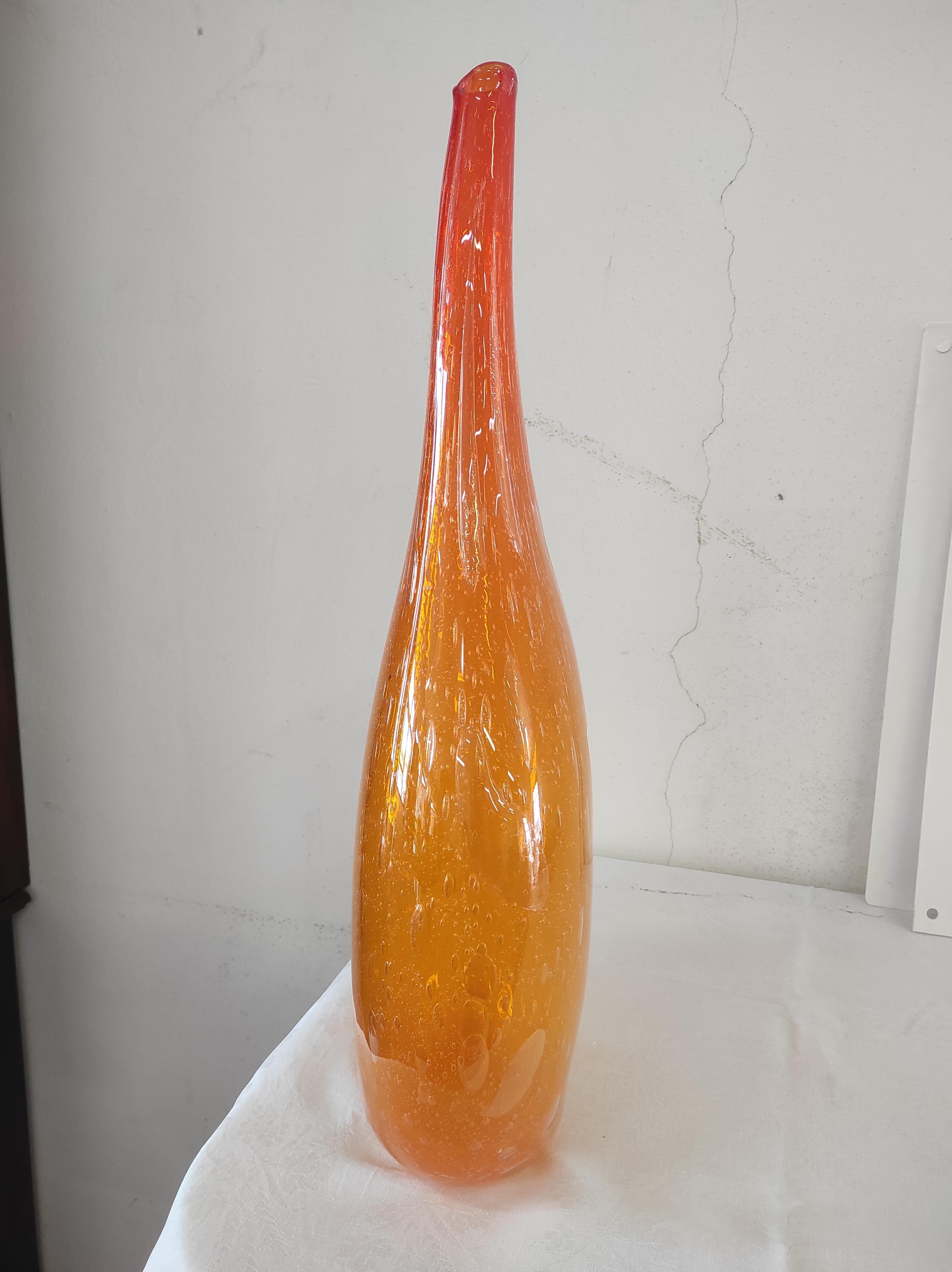 Orange-colored Murano blown glass vase.
The size of this jar means that it is very difficult to execute because the longer the top of the jar is stretched, the greater the risk of breakage.
It was created by master glassmaker Sergio Costantini using