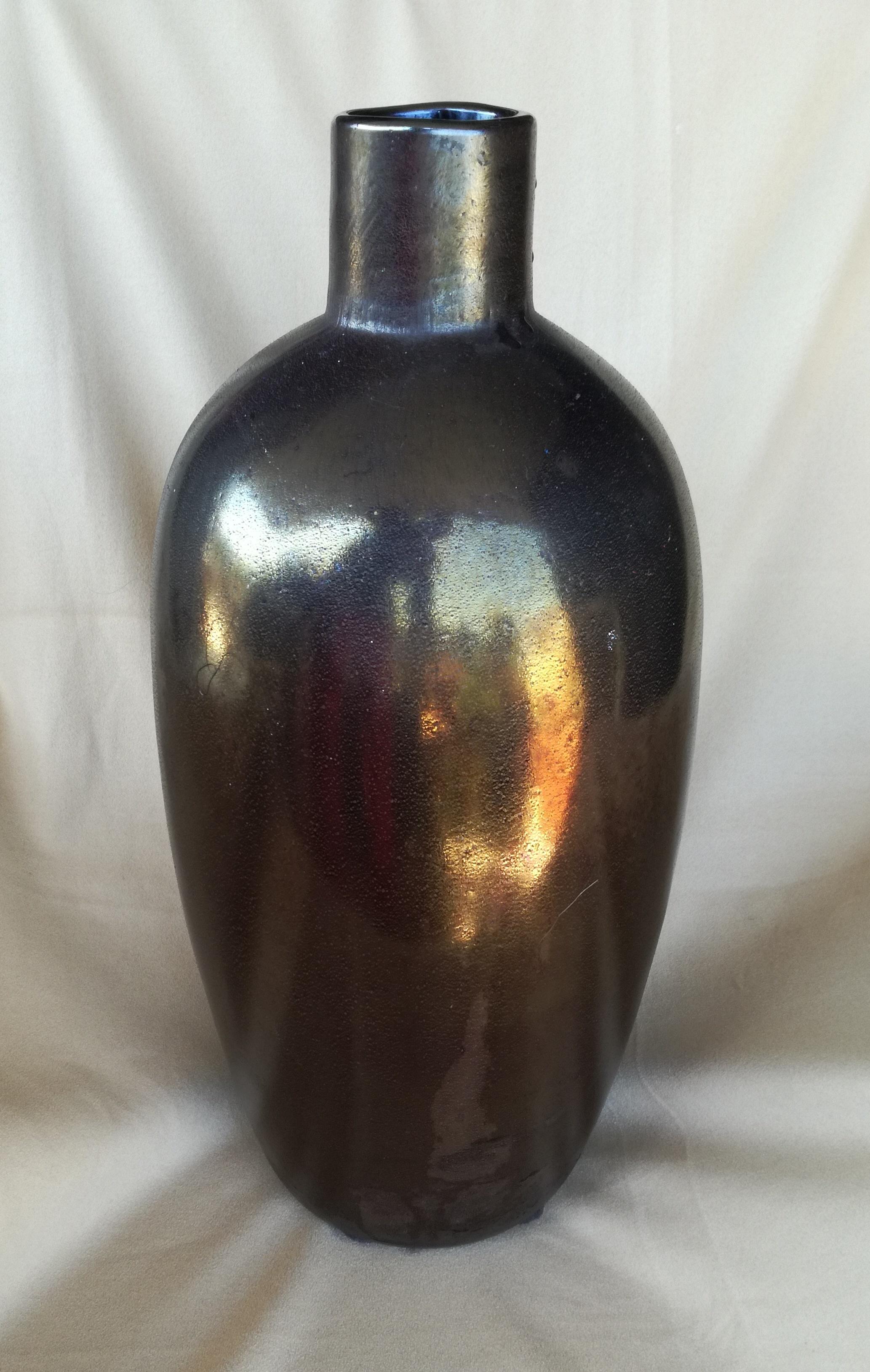 Vaso in vetro Murano sabbiato al silicio, nello stile di alfredo barbini. vetro di forte spessore trattato in superficie con sabbia al silicio. il colore e' un bronzo ramato a seconda della luce. il vaso e pesante. e robusto.