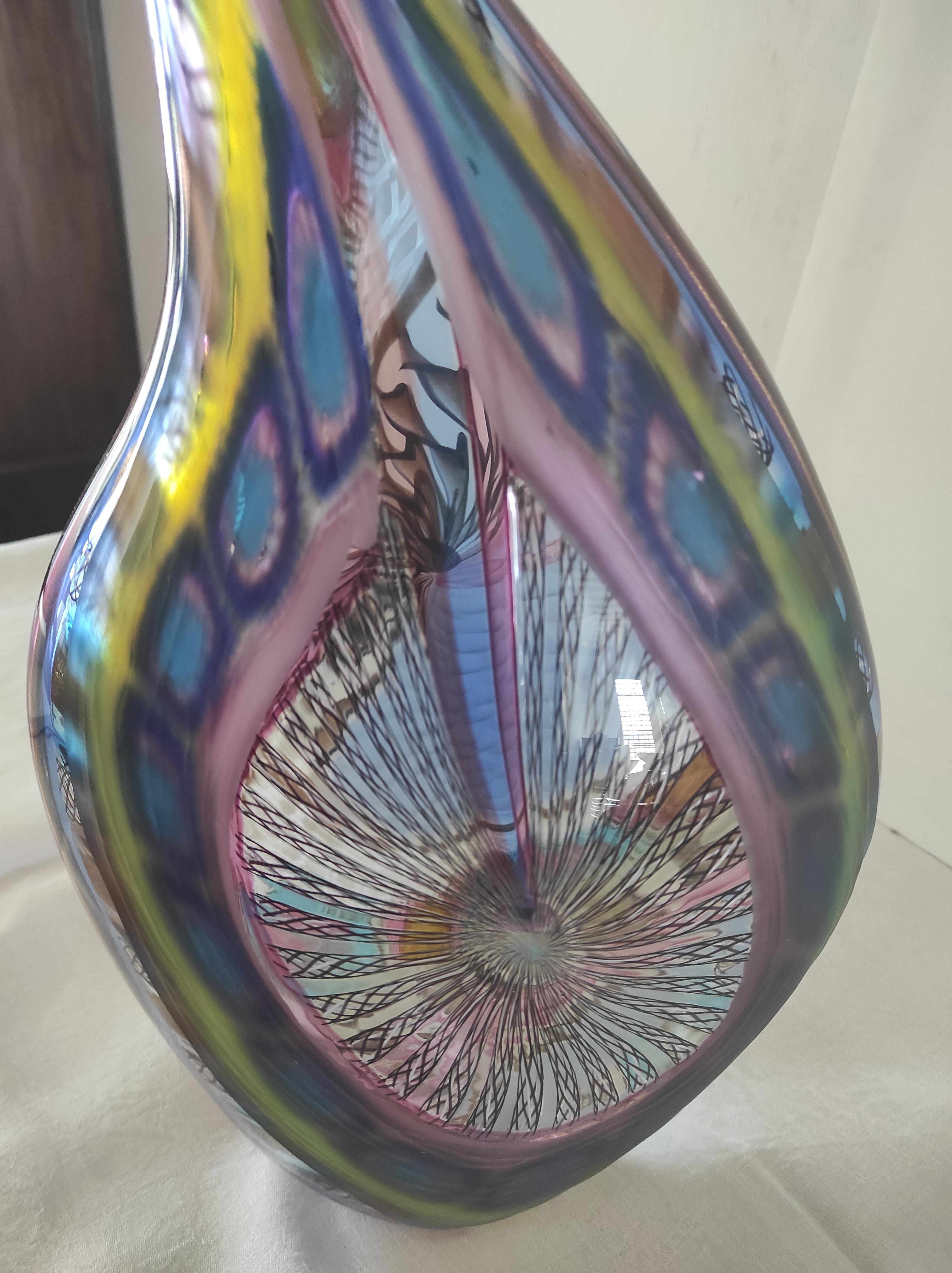 This Murano blown glass vase was created by Vetreria d' Este e Zane of Murano.
Different types of workmanship are present in this vase:
Lattice work: a technique that uses transparent glass rods (glass rods) containing straight or intertwined white