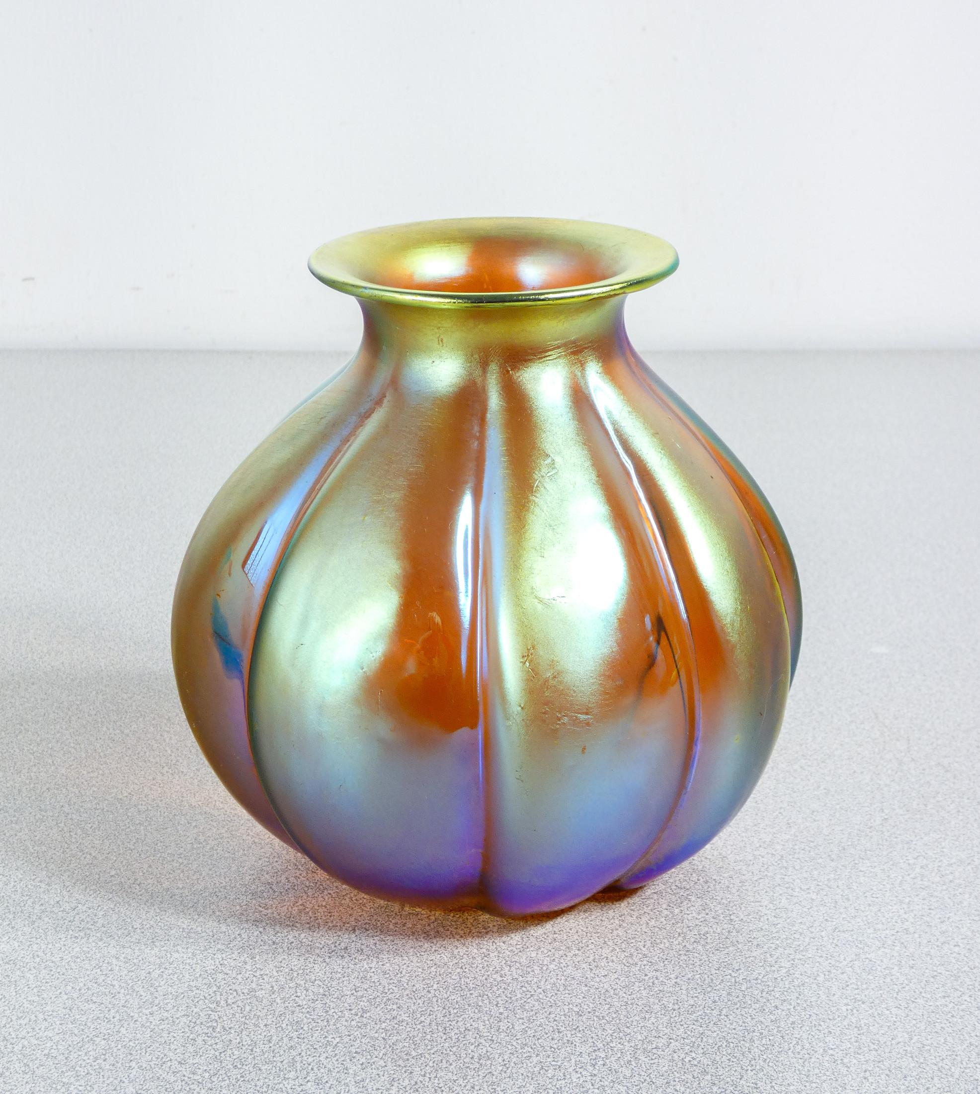 Vaso in vetro
soffiato iridescente
WMF serie Myra.

ORIGINE
Germania

PERIODO
Anni 20/30

MARCA
WMF

MODELLO
Serie Myra

MATERIALI
Vetro soffiato iridescente

DIMENSIONI
Altezza: 15 cm
Ø 15 cm

CONDIZIONI
Il vaso è in ottime condizioni, come è