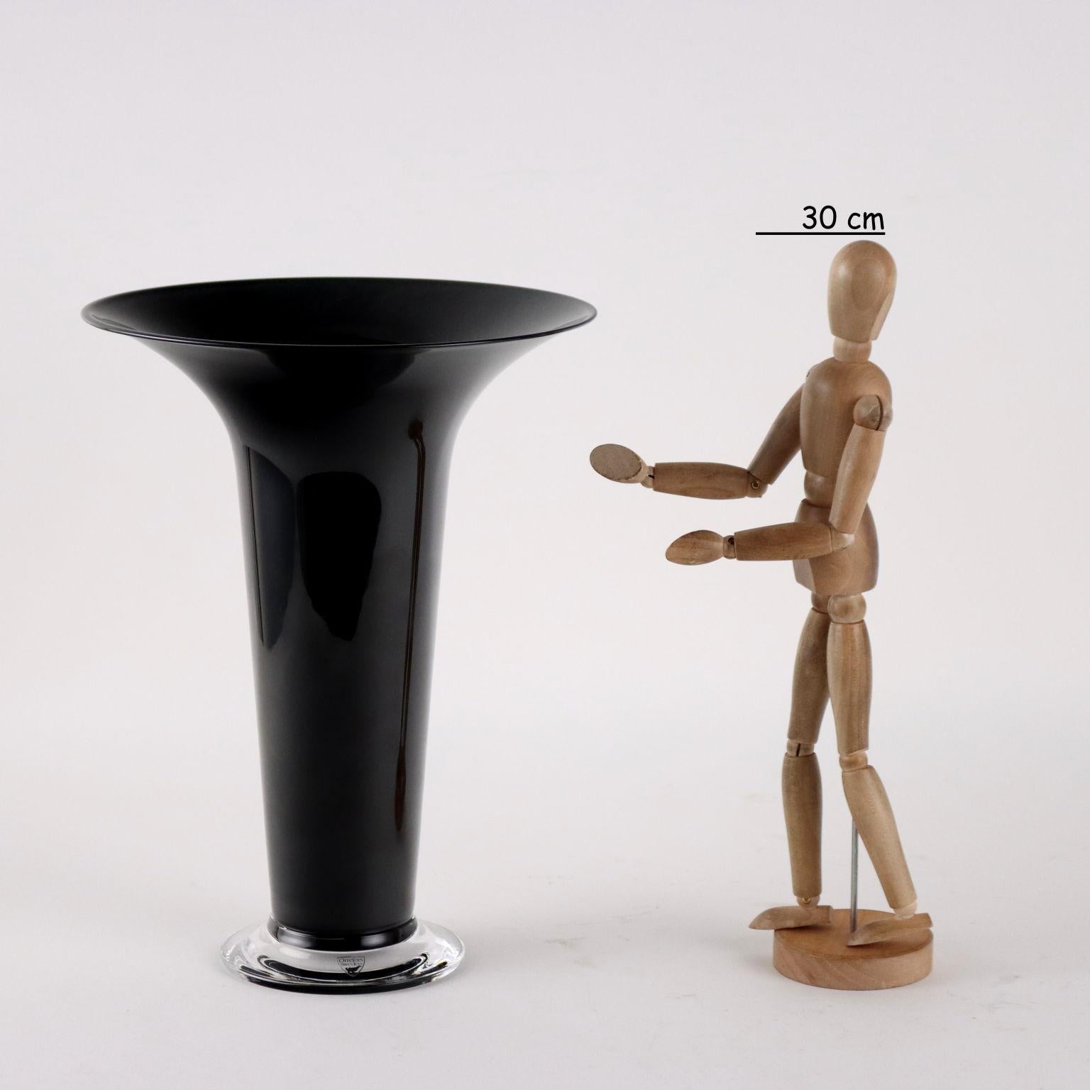 Vase trompette en verre noir et incolore. Étiquette et marque du fabricant sur la base.