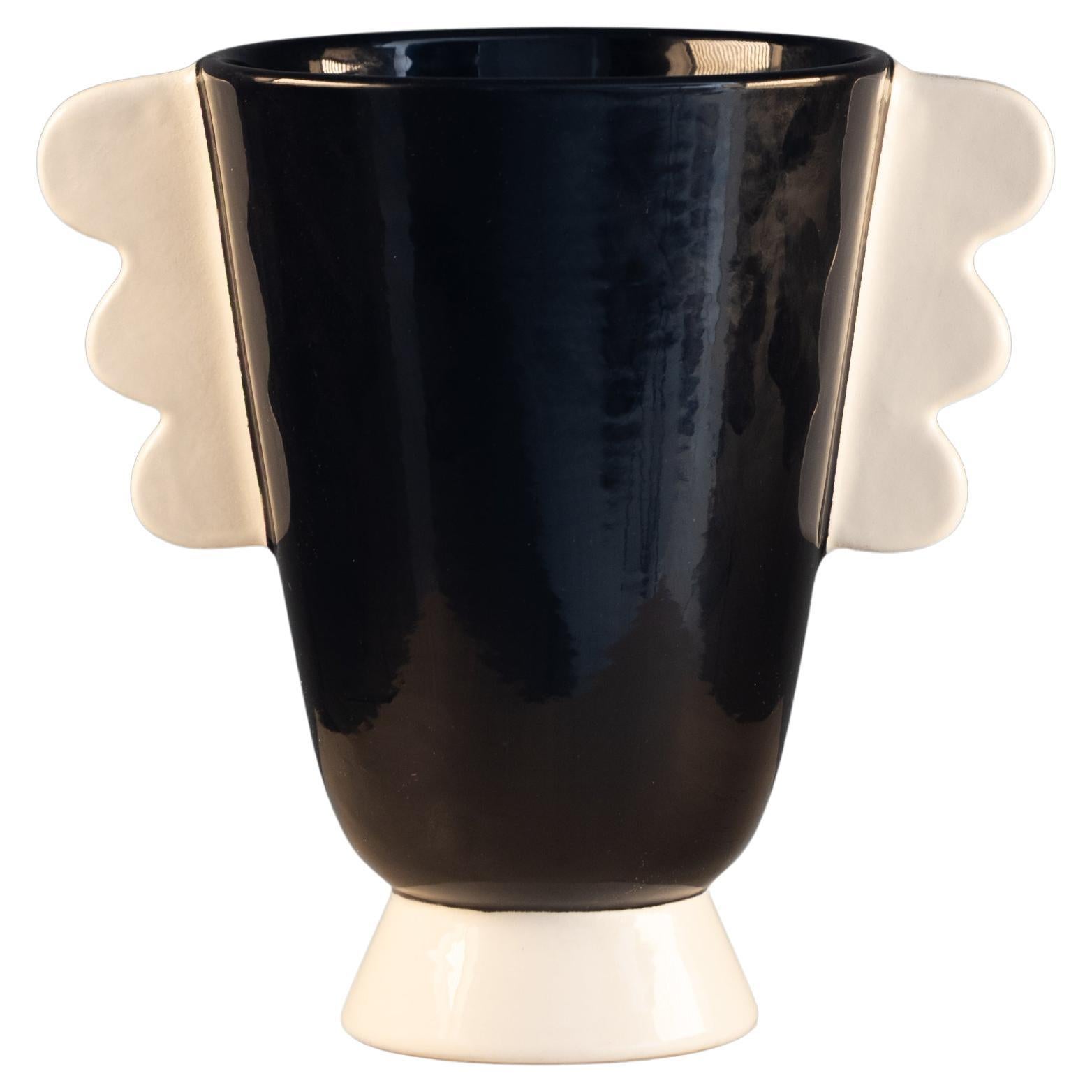 Raro vaso postmoderno in ceramica smaltata in bianco e nero, prodotto da Rometti negli anni Ottanta. Il modello, ora fuori produzione, rappresenta una figura stilizzata della Vittoria Alata, reinterpretata in chiave contemporanea con linee