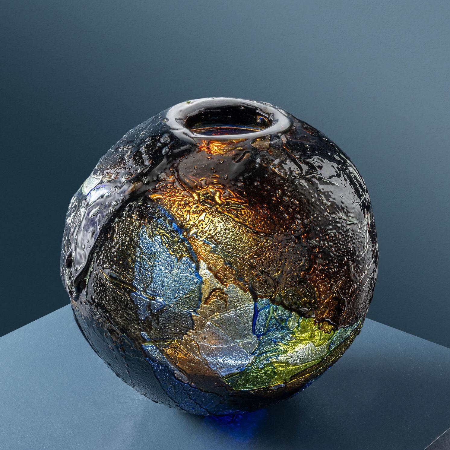 Vaso scultura ‘Geacolor’ disegnato da Gae Auelenti per una produzione Venini.
Il vaso, realizzato in vetro tramite la tecnica del riporto dei colori a caldo e a mano volante, è caratterizzato da sporgenze non regolari dalle forme più varie che