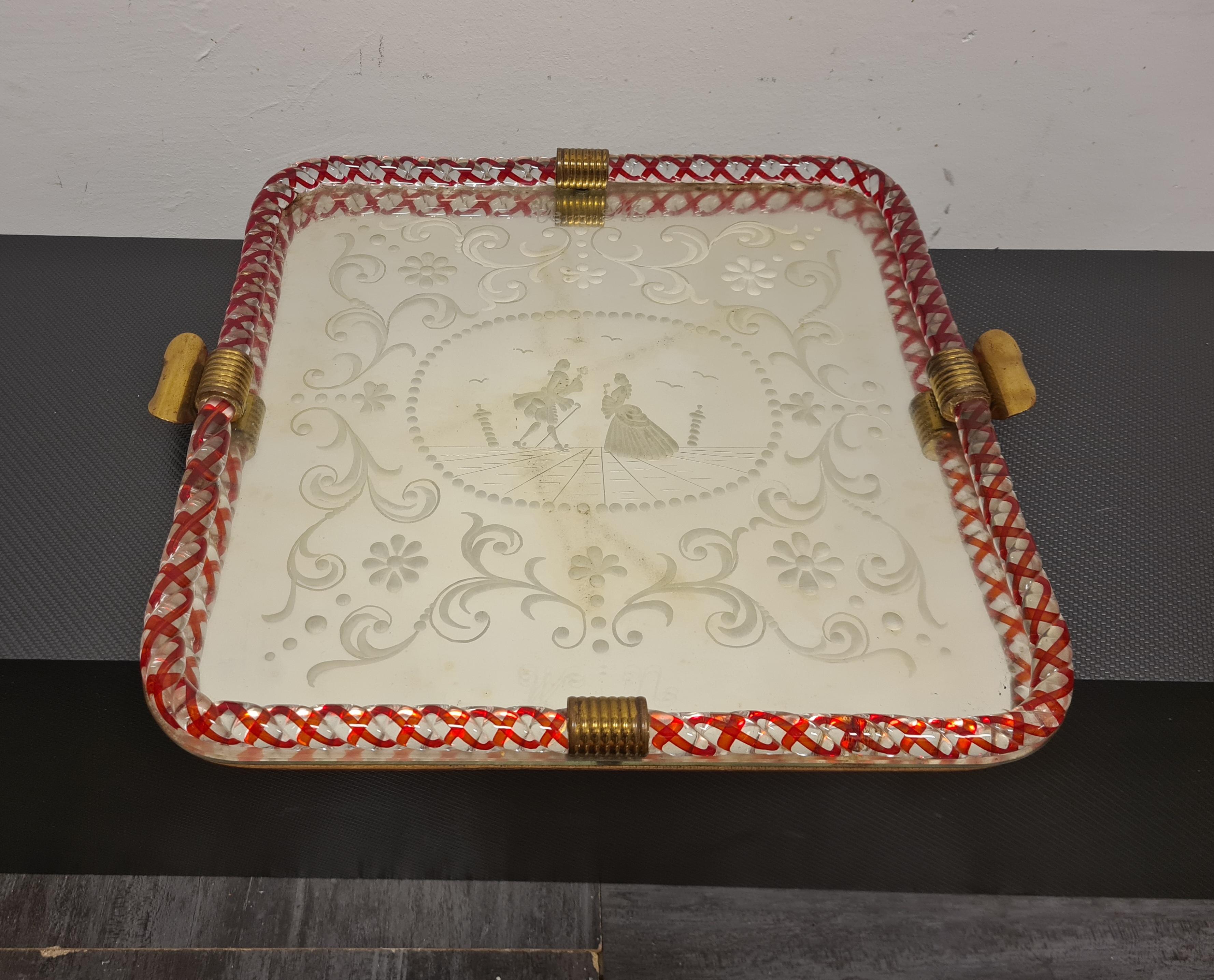 Mirrored tray by Ercole Barovier

Refined 1950s' tray with engraved mirror top.

Submerged glass rope edging and brass handles and details.

A scene depicting two lovers is engraved on the mirror top.

The mirror being mercury has inevitable signs