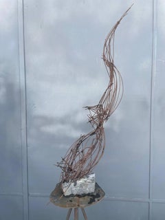 Un ser aferrado a una roca, escultura figurativa simbolista, metal